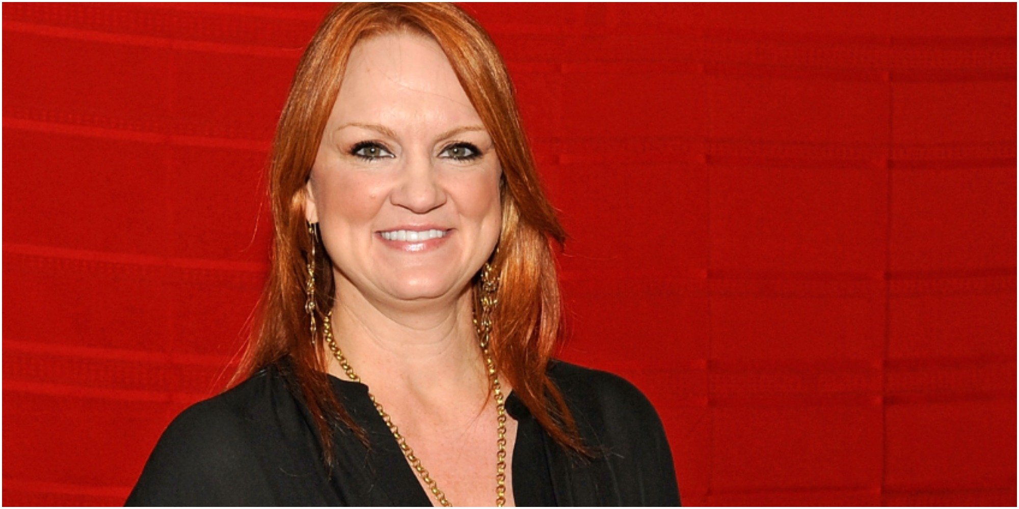 Ree Drummond poses in front of a red background for a press photo.