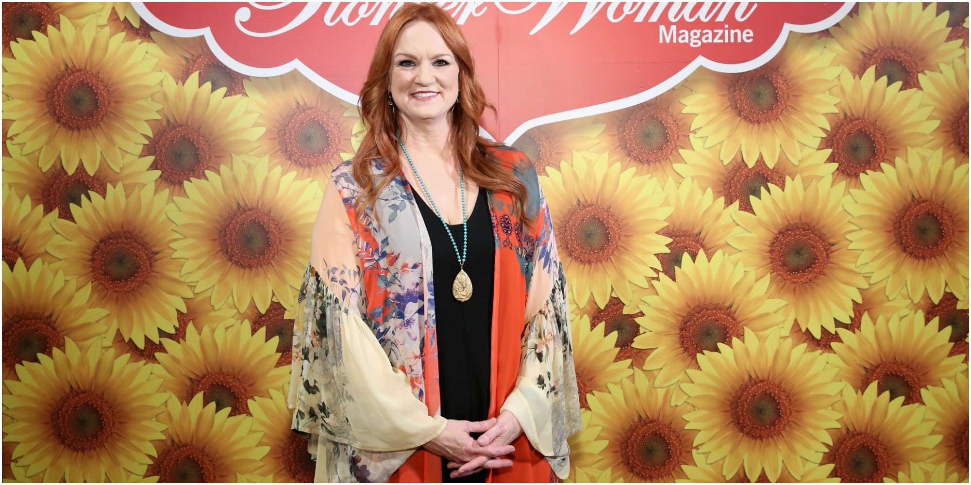 Ree Drummond poses in front of a flowered wall.