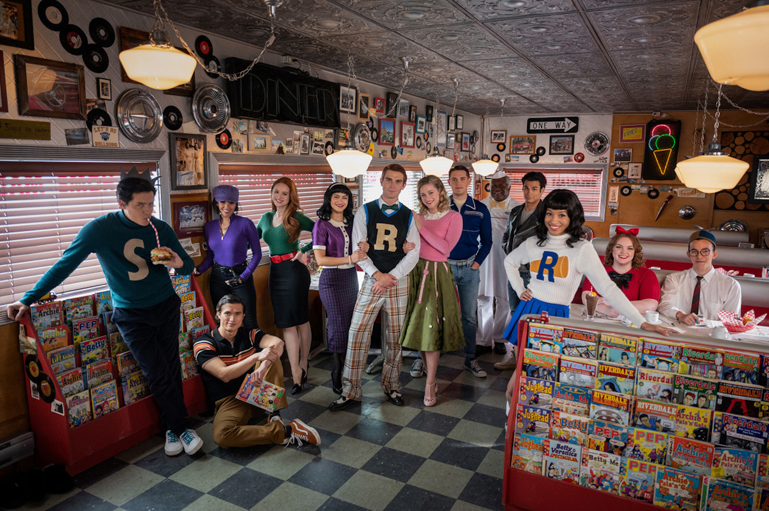 The cast of the Riverdale 100th episode in Pop's Chock'lit Shoppe wearing '50s attire.