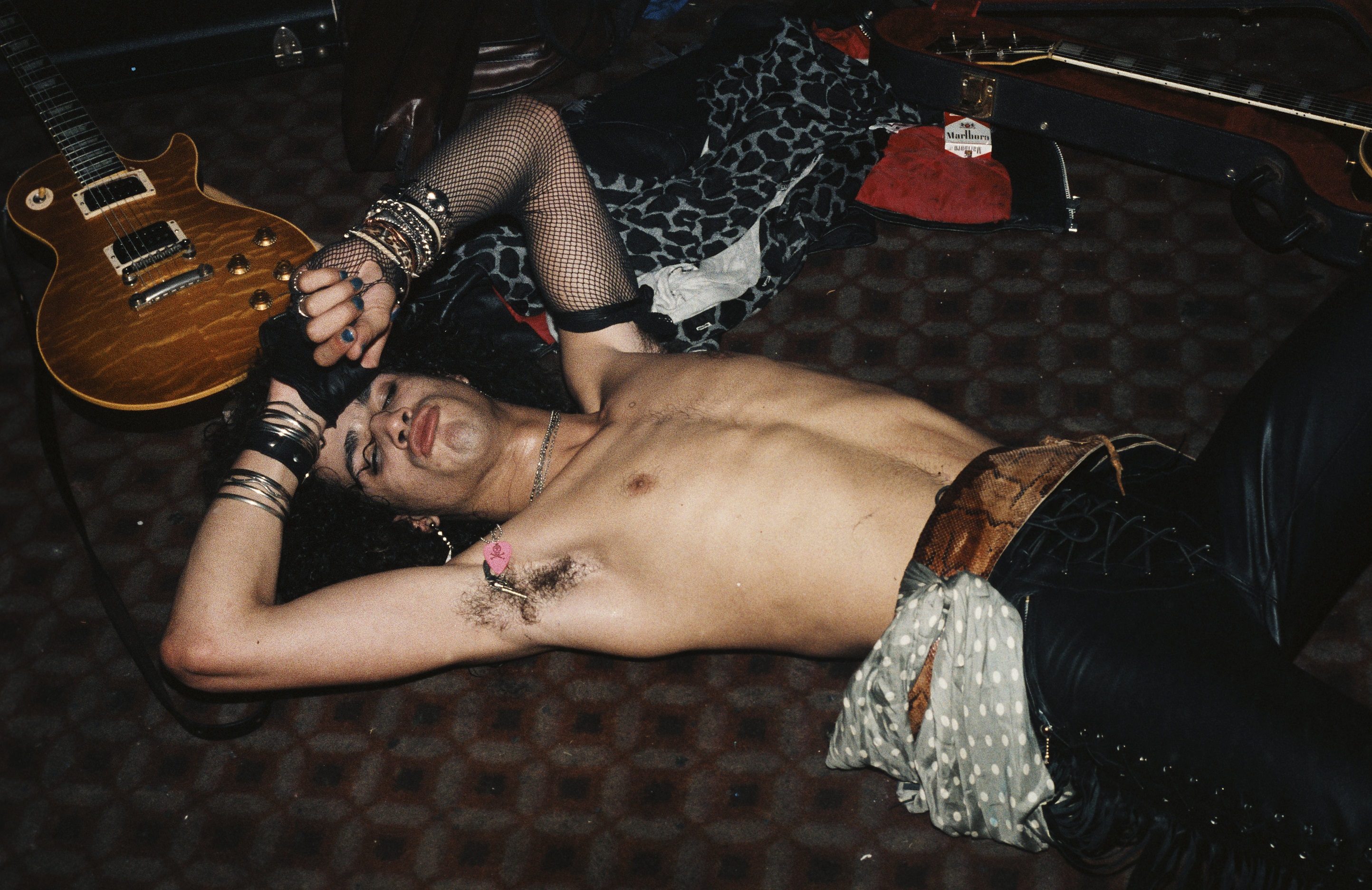 Slash of Guns N' Roses lying on the floor near a guitar