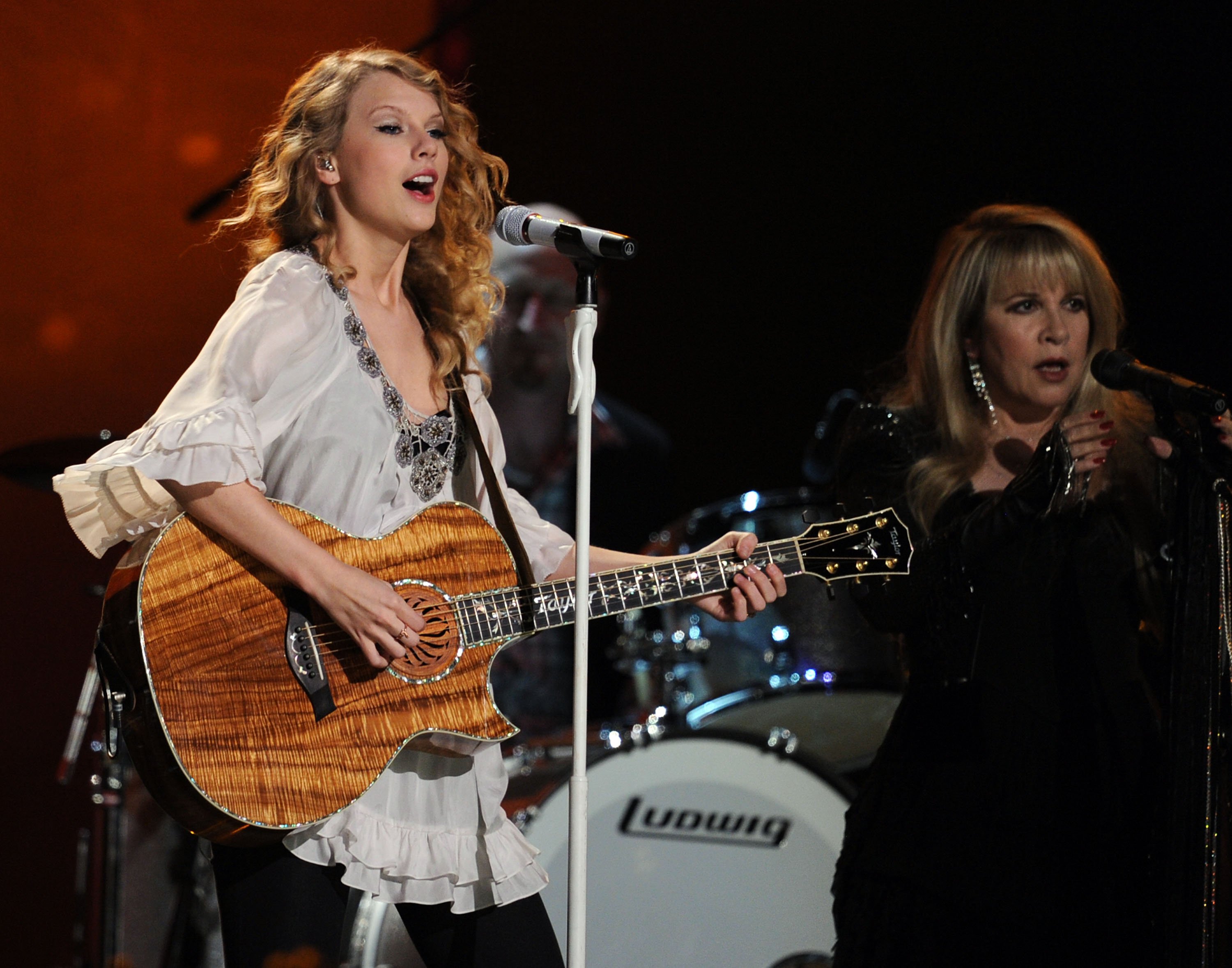 Taylor Swift holding a guitar next to Stevie Nicks