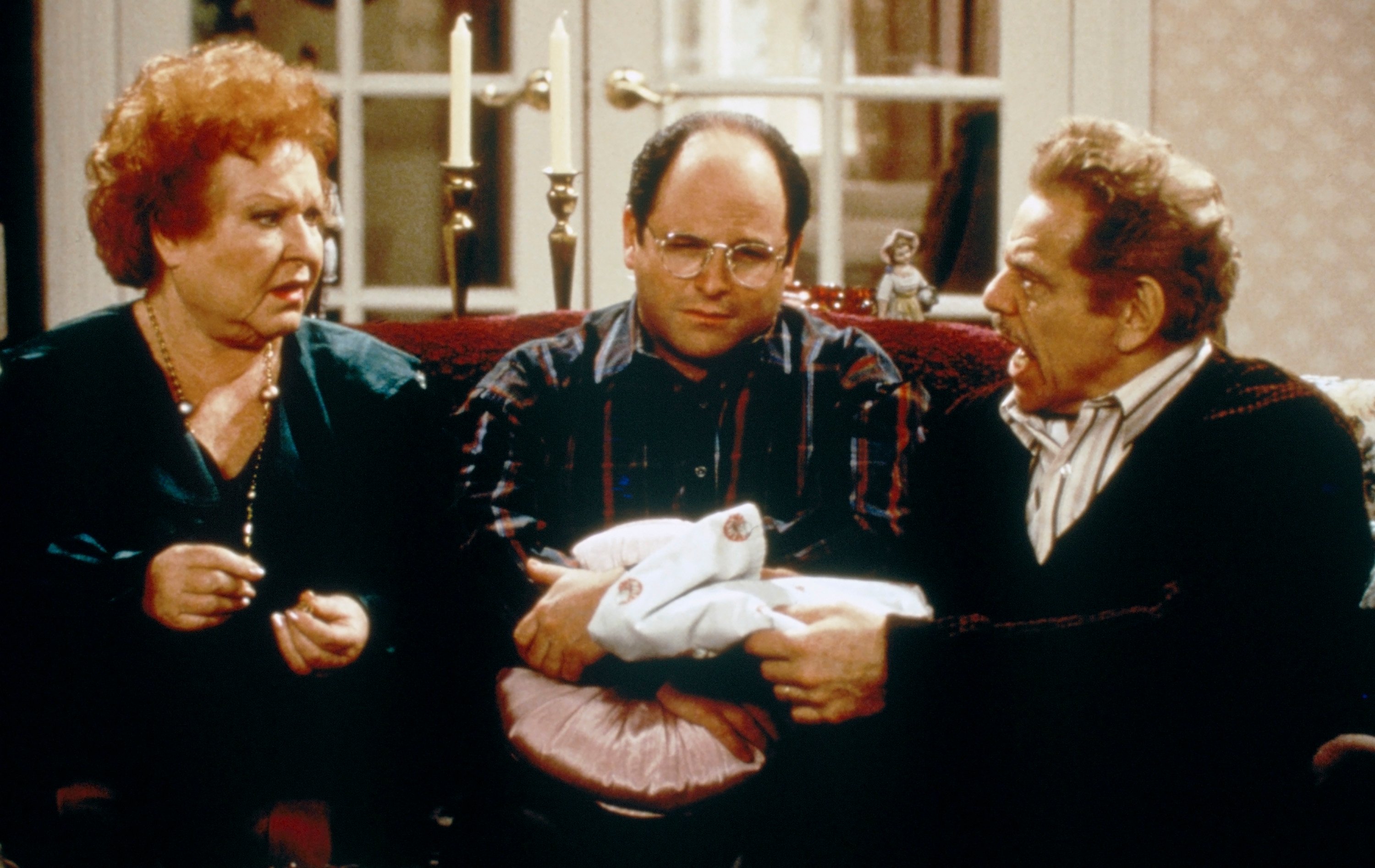 Estelle Harris as Estelle Costanza, Jason Alexander as George Costanza and Jerry Stiller as Frank Costanza in their living room in an episode of 'Seinfeld'