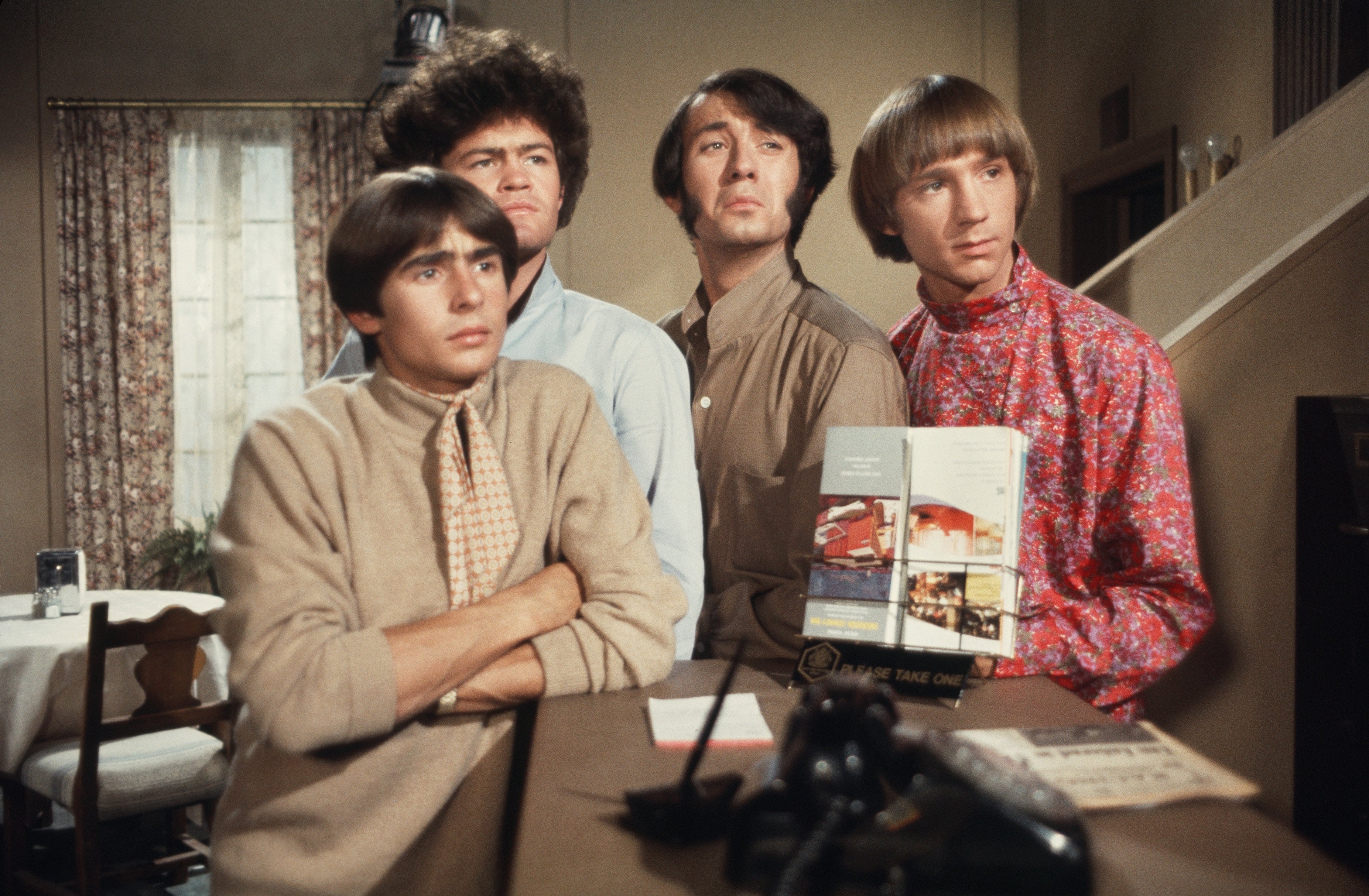 The Monkees' Davy Jones, Mickey Dolenz, Peter Tork, and Mike Nesmith at a piano