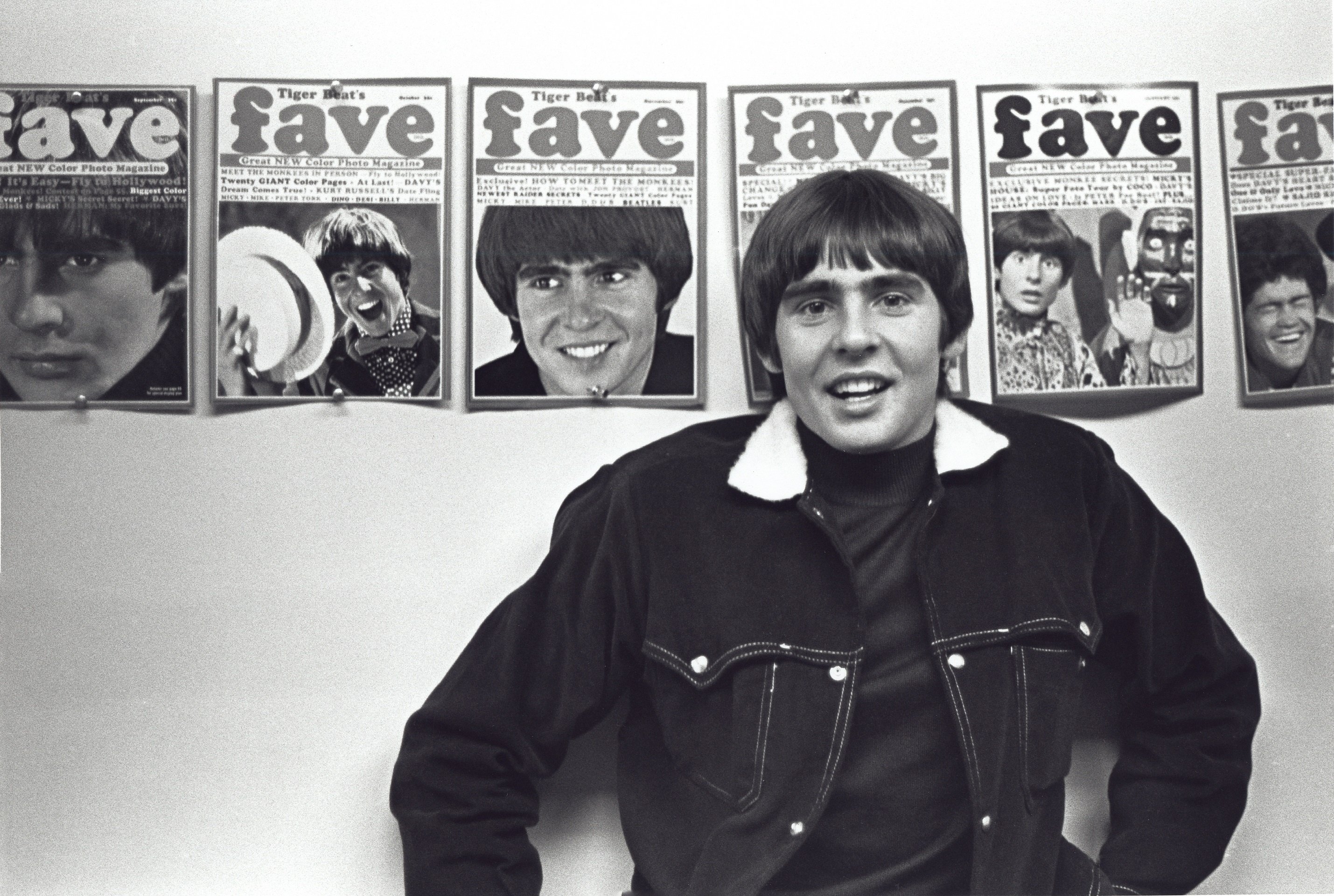The Monkees' Davy Jones in front of posters