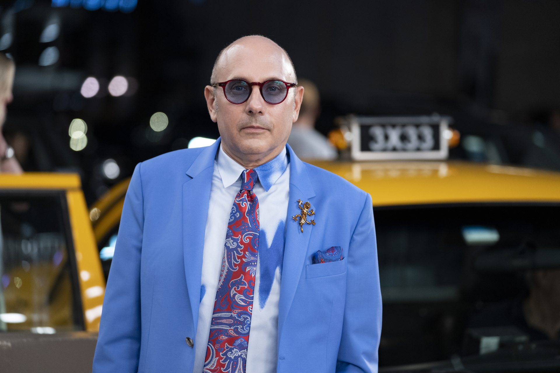 Willie Garson stands in front of a yellow tax during the filming of 'And Just Like That...'
