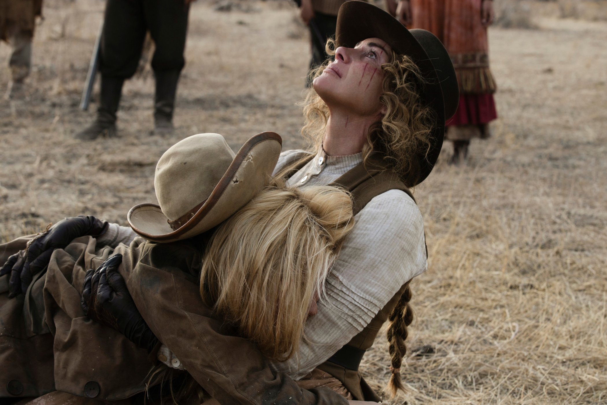 Elsa Dutton crying in Margaret Dutton's arms as Margaret looks to the sky while on her knees in '1883'