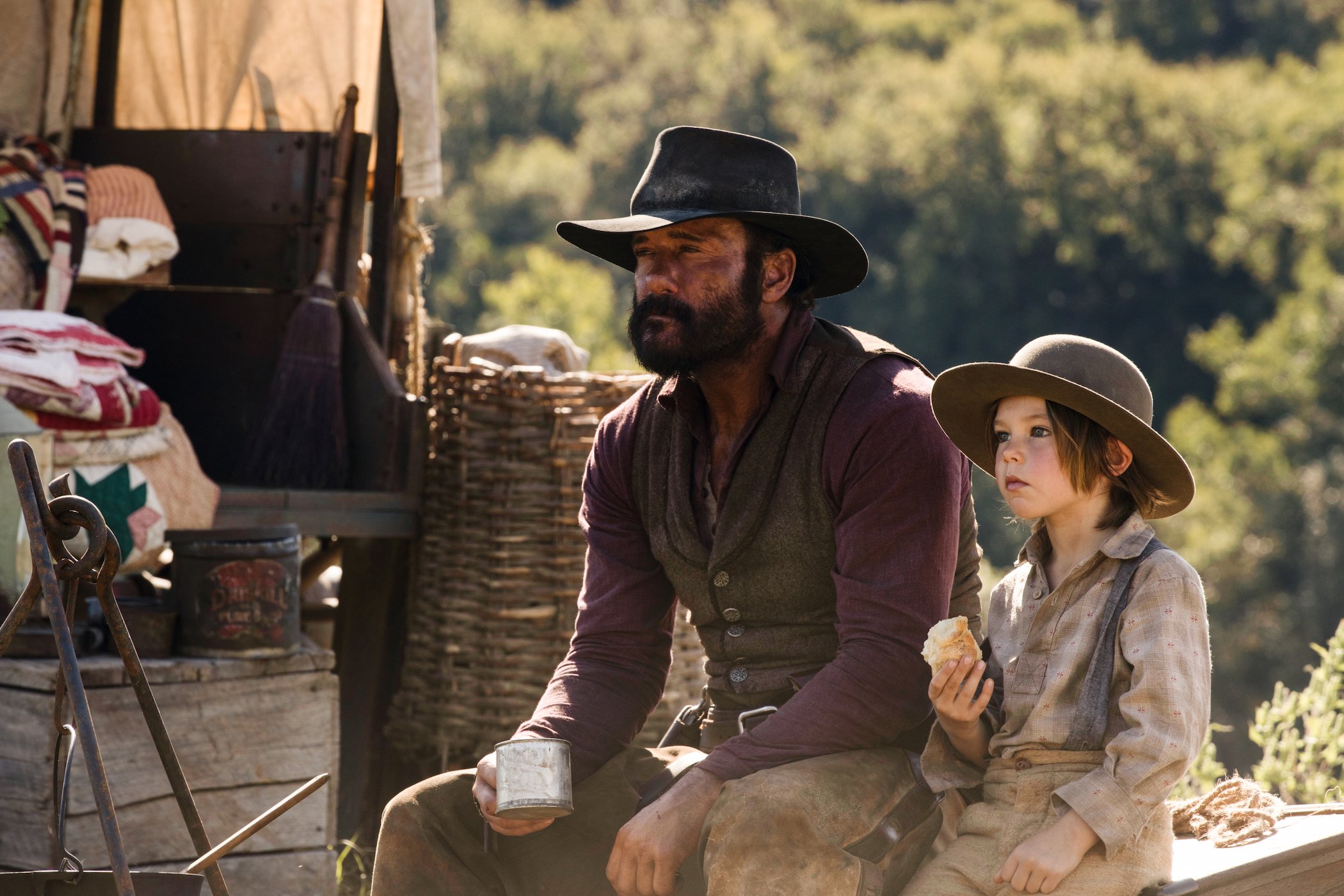 Tim McGraw as James Dutton and Audie Rick as John sitting next to each other in '1883'