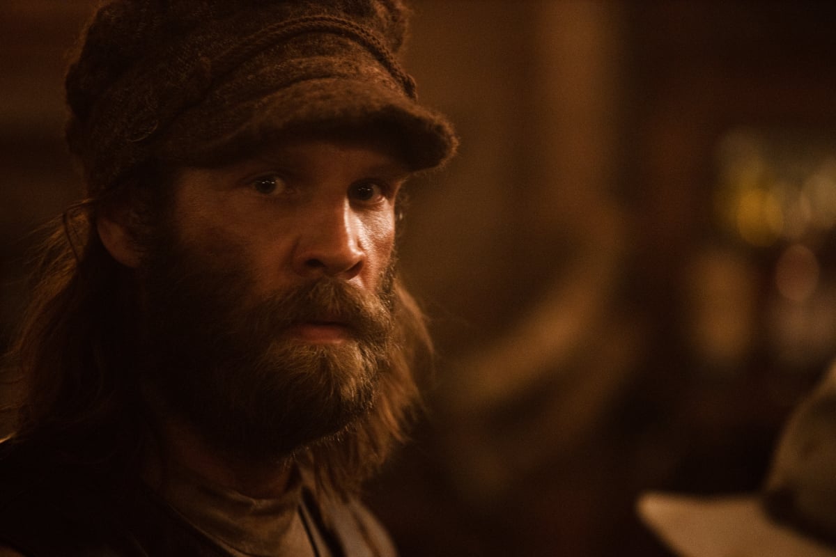 Marc Rissman as Josef of the Paramount+ original series 1883. Josef has a beard and wears a hat.