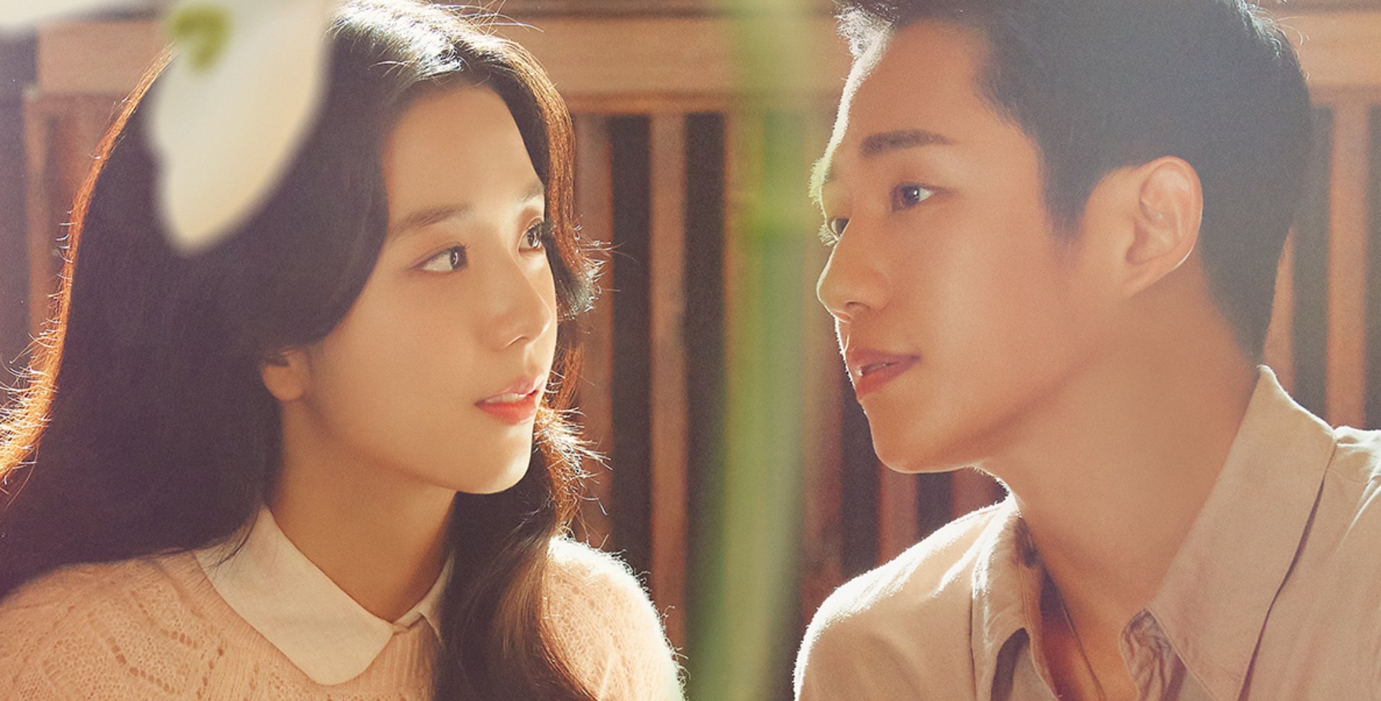 Actors Jisoo and Jung Hae-in for 'Snowdrop' K-drama wearing beige shirts looking at each other.