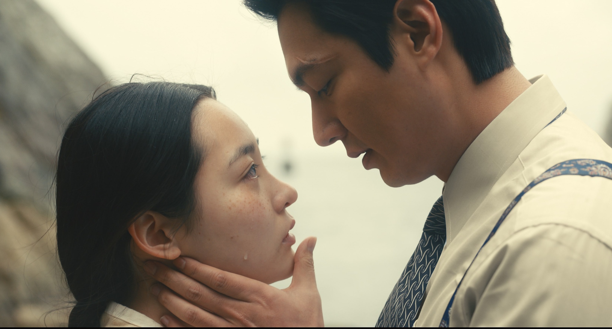 Actors Kim Min-ha and Lee Min-ho in 'Pachinko' looking at each other.