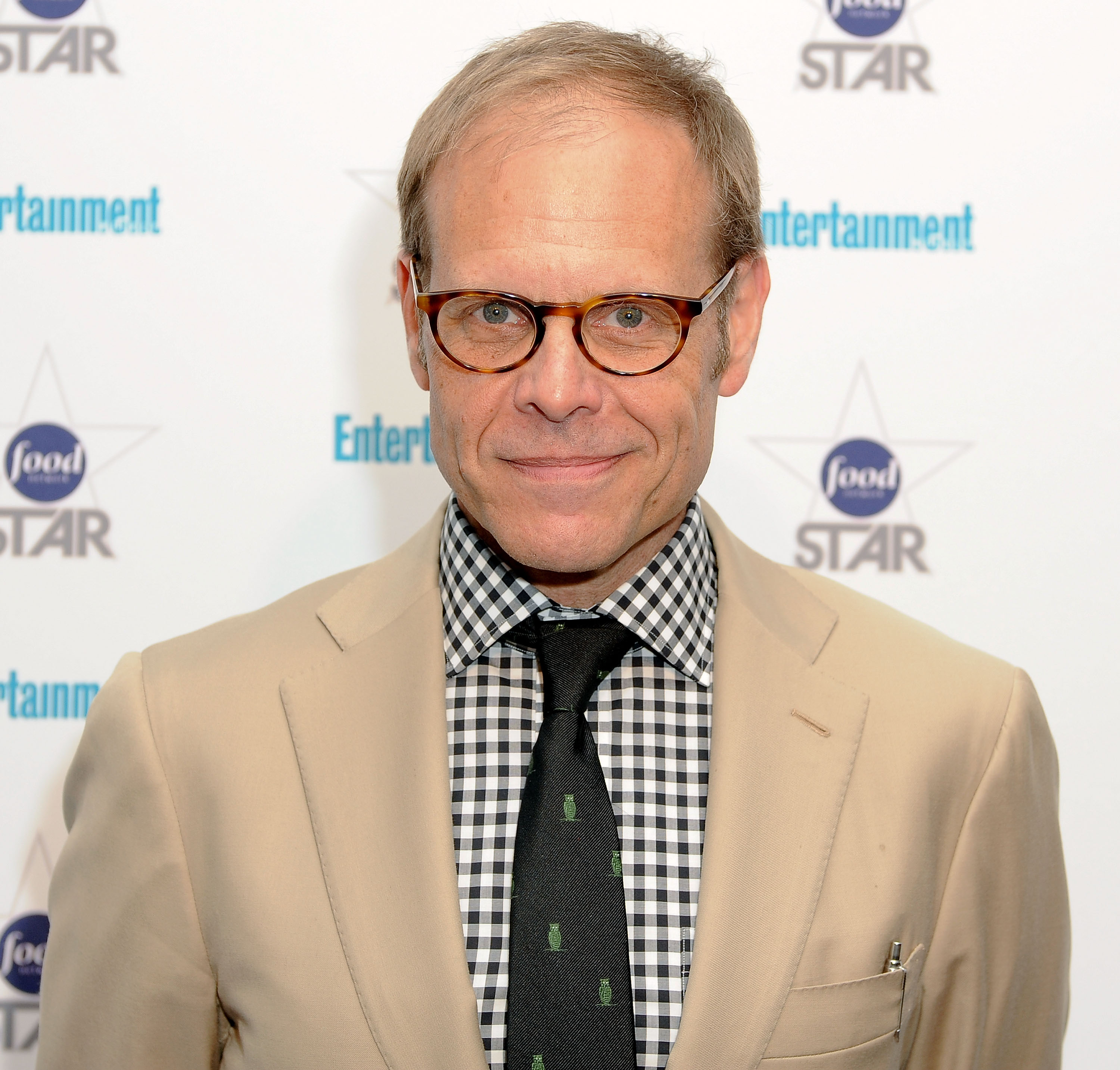 Food Network star Alton Brown wears a beige jacket in this 2012 photo.