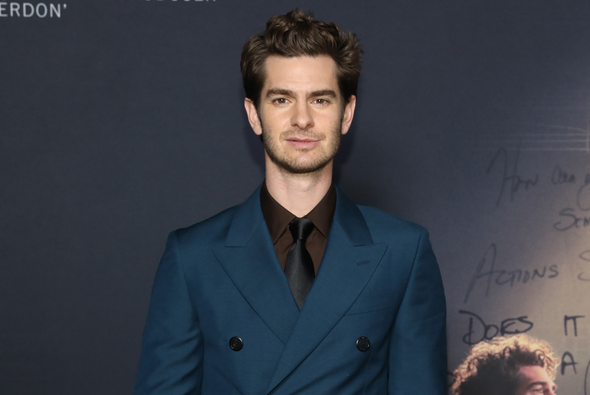 'Spider-Man: No Way Home' star Andrew Garfield wearing a blue suit and looking straight at the camera.