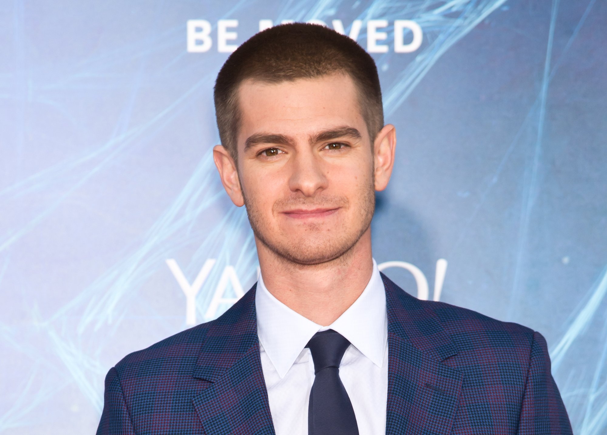 Andrew Garfield, who returns in 'Spider-Man: No Way Home' alongside Tobey Maguire, wears a blue suit over a white button-up shirt and black tie.