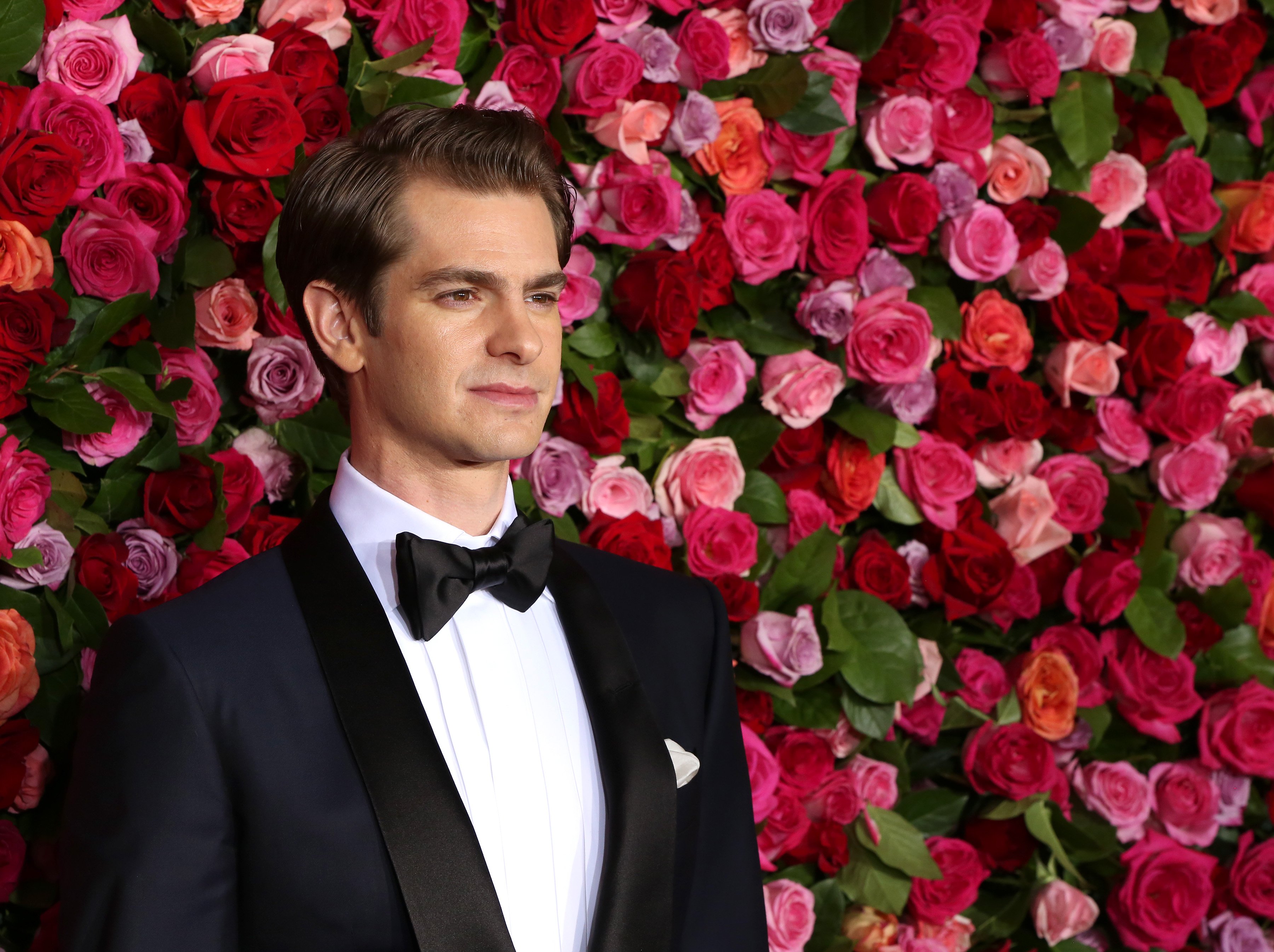 Andrew Garfield, who returned to play Peter Parker alongside Tobey Maguire in 'Spider-Man: No Way Home,' wears a dark blue suit over a white button-up shirt and black bow tie.