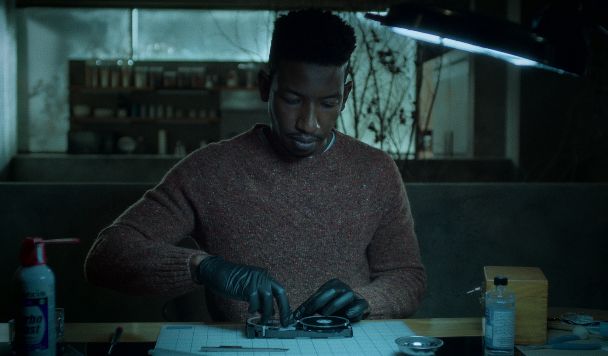 'Archive 81' star Mamoudou Athie restoring a VHS cassette tape in a production still from the series