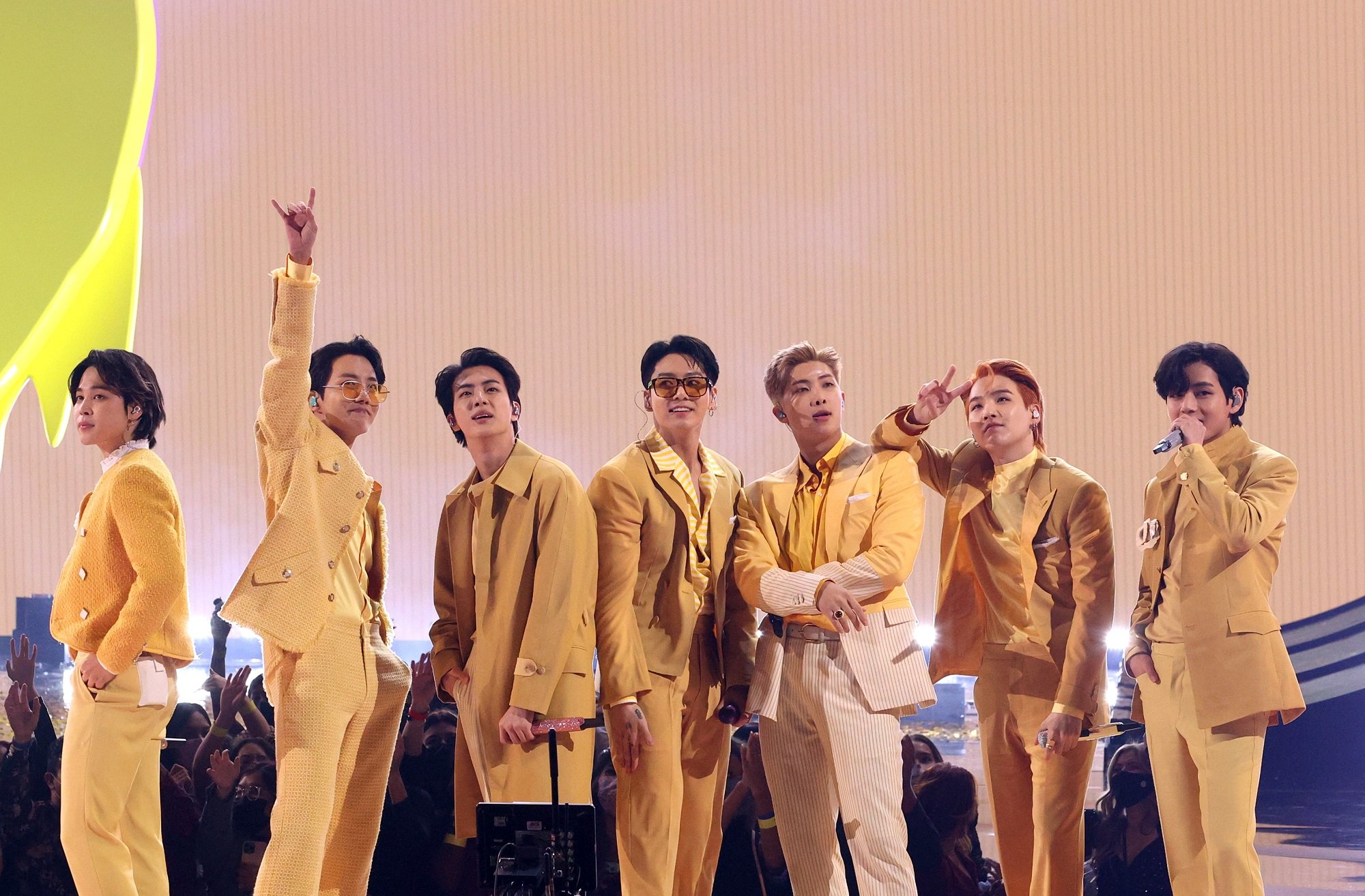 Jimin, J-Hope, Jin, Jungkook, RM, Suga, and V of BTS stand onstage at the 2021 American Music Awards