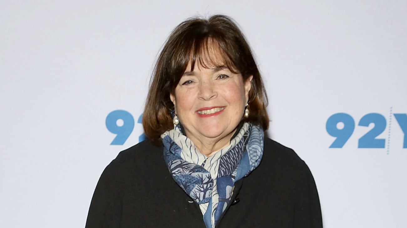 Barefoot Contessa Ina Garten smiles as she poses for cameras wearing a blue scarf and black top