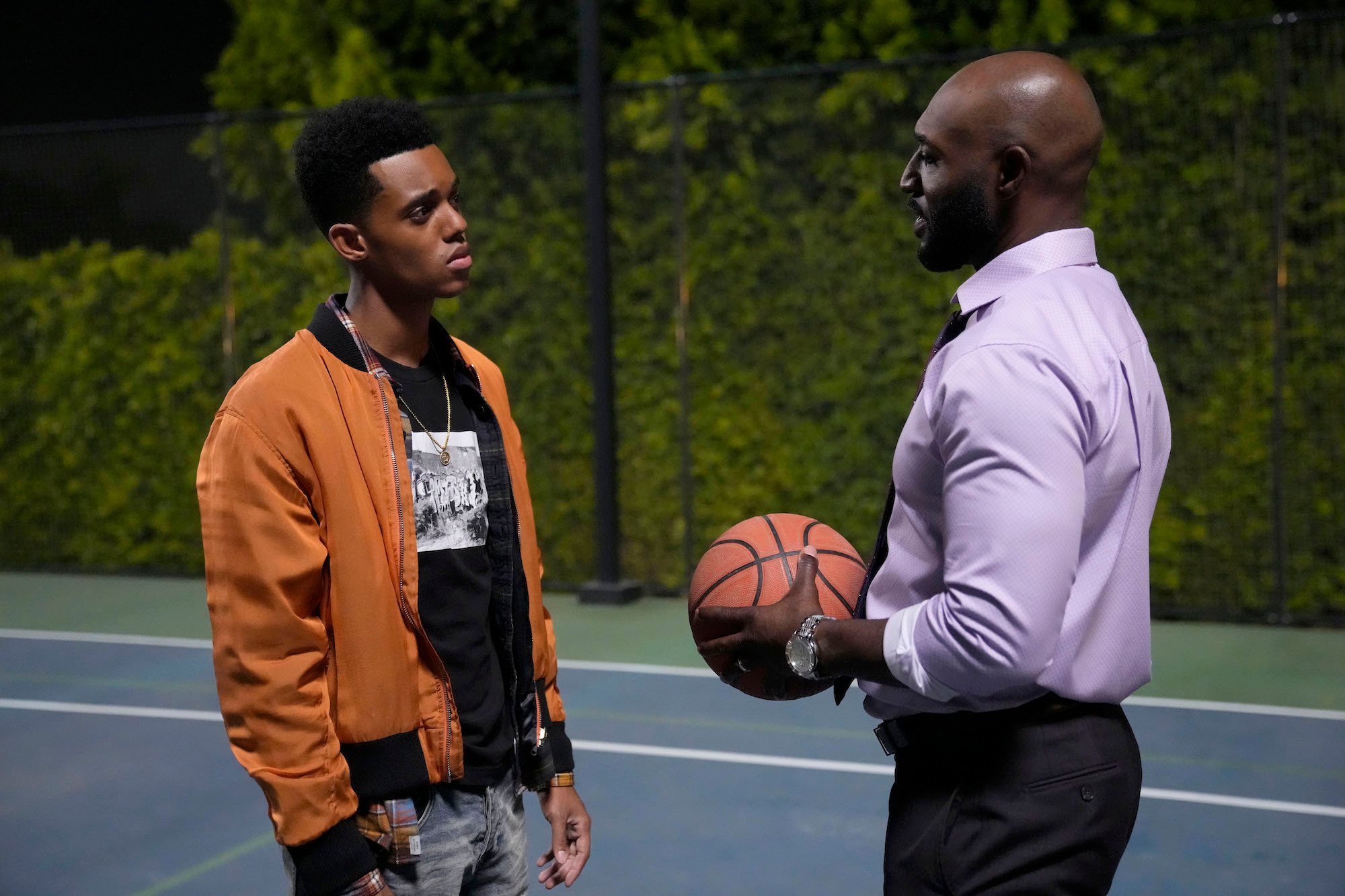 'Bel-Air' Uncle Phil Adrian Holmes holds a basketball and speaks to Jabari Banks' character Will Smith.