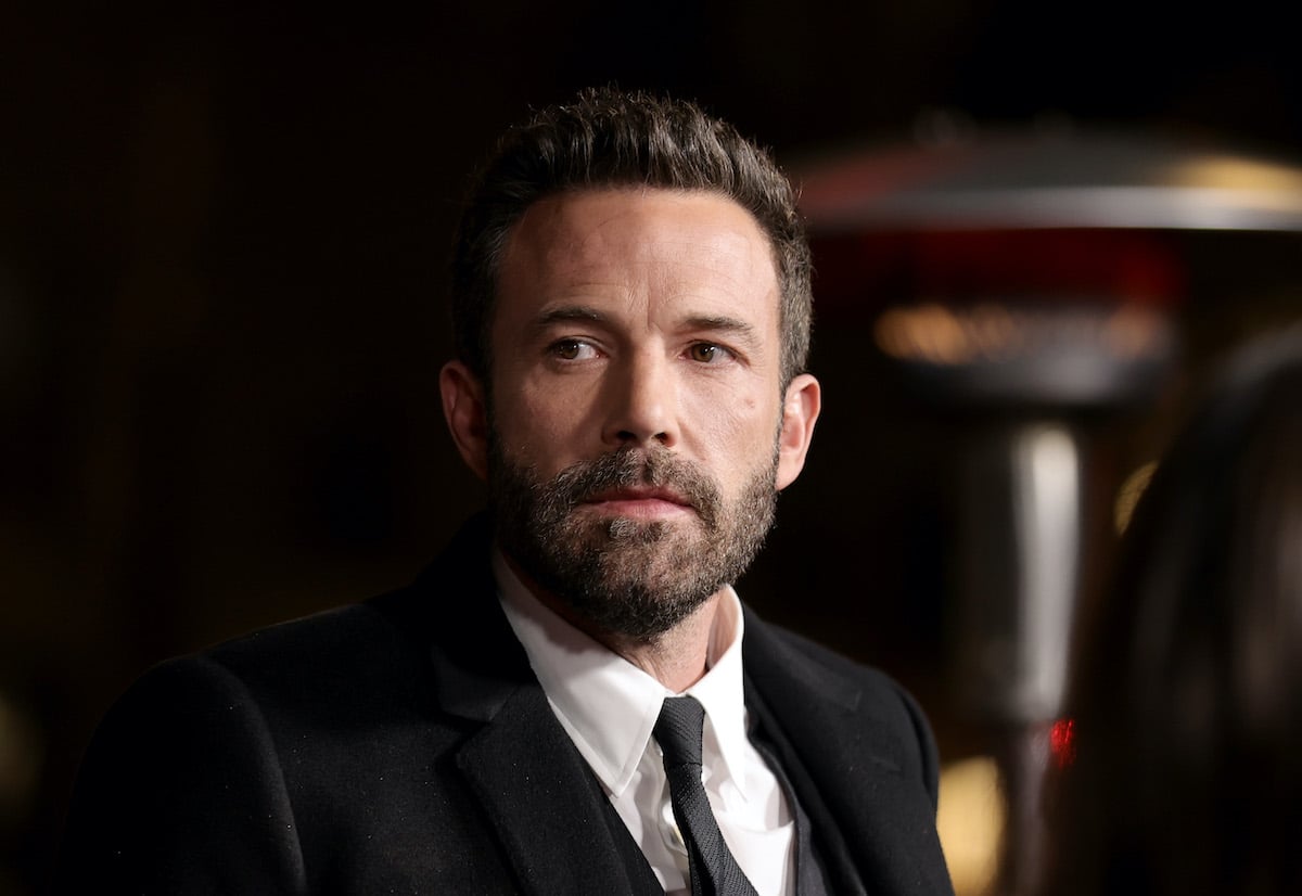 Ben Affleck wears a black suit and looks off-camera