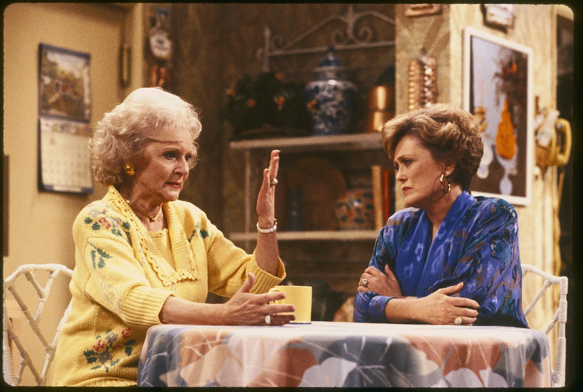 'The Golden Girls' actor Betty White in a yellow sweater, and Rue McClanahan wearing a blue blouse; sit in the kitchen.
