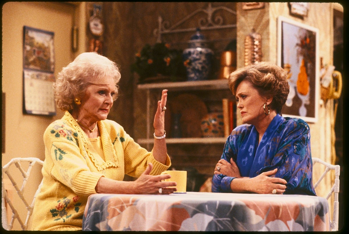 'The Golden Girls' actor Betty White in a yellow sweater, and Rue McClanahan wearing a blue blouse; sit in the kitchen.