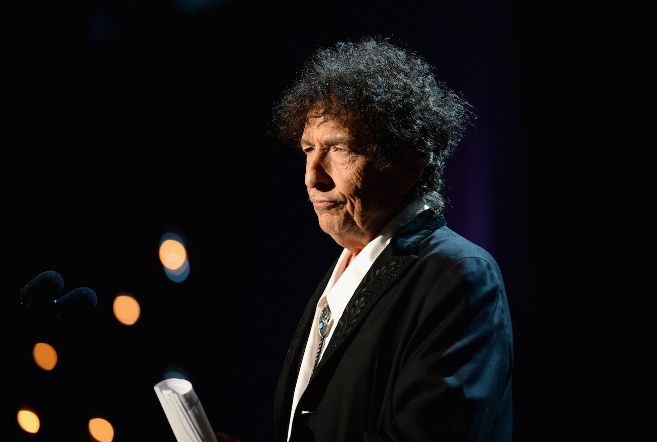 Bob Dylan wearing a suit while speaking at the 2015 MusiCares Person of the Year Gala.