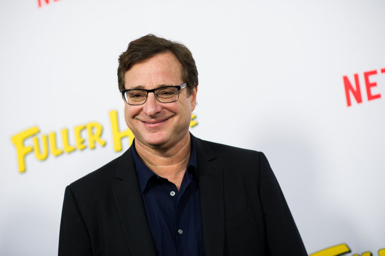 Bob Saget smiles wearing a black outfit 