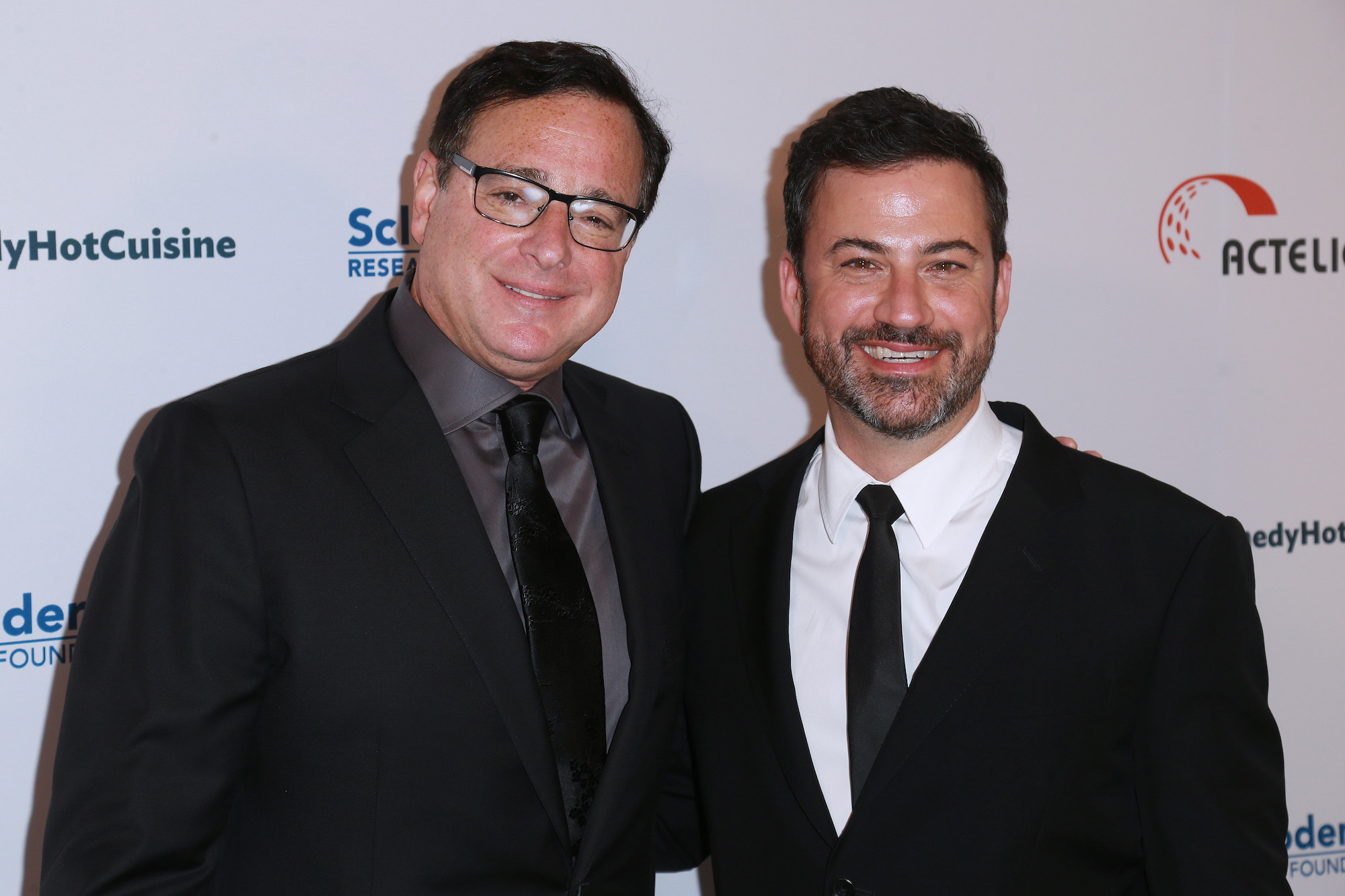 Bob Saget puts his arm around Jimmy Kimmel at a SRF red carpet