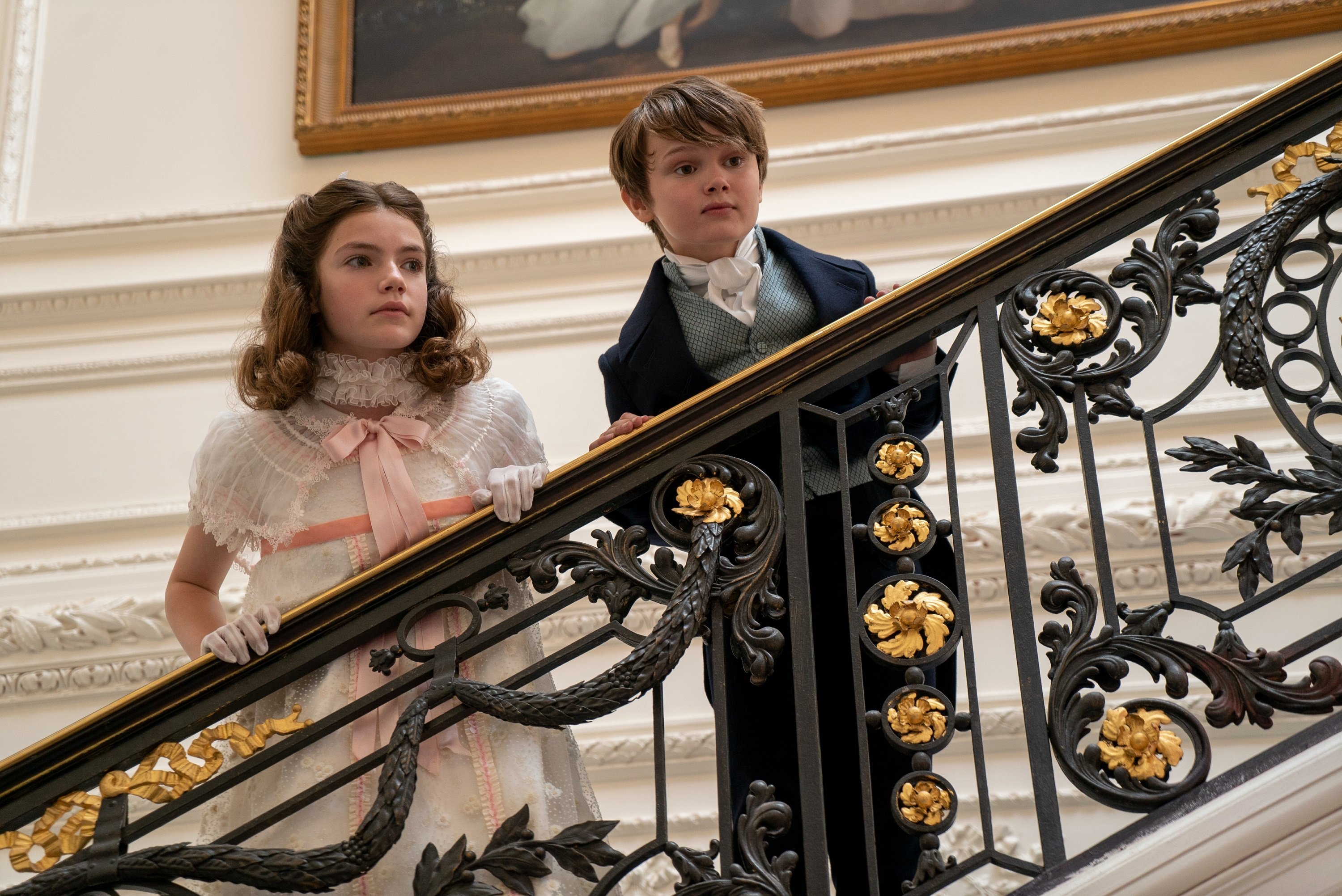 'Bridgerton' siblings Hyacinth and Gregory looking out over a banister on the stairs