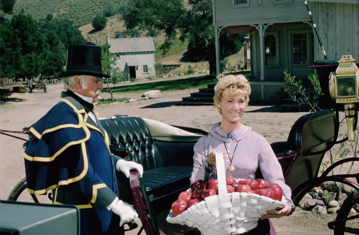 Charlotte Stewart of Little House on the Prairie holding a basket of apples