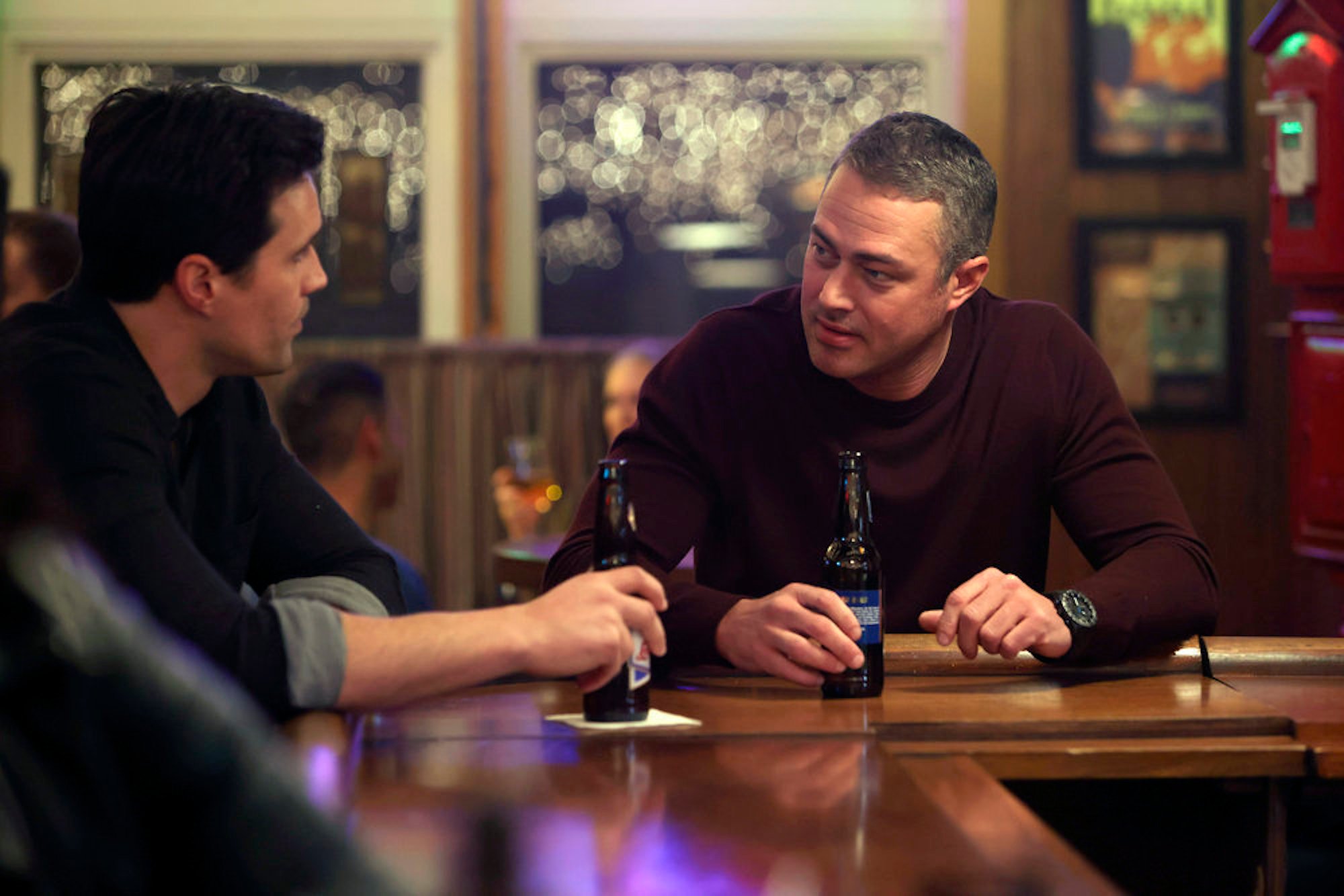 Jason Pelham and Kelly Severide in 'Chicago Fire' Season 10 sitting at a bar talking