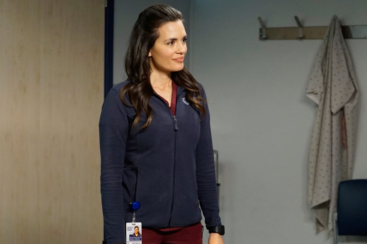 Torrey DeVitto as Natalie Manning in Chicago Med. Natalie wears maroon scrubs with a dark blue jacket over them.