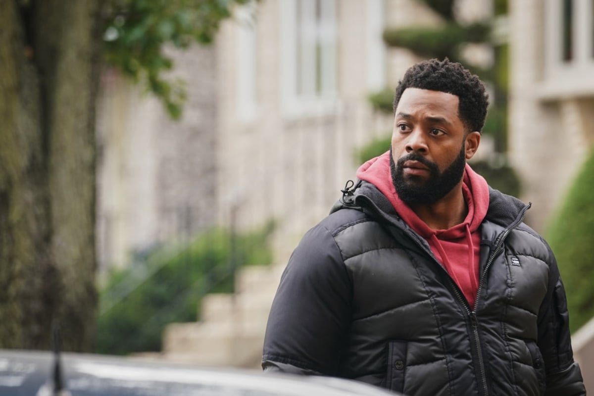 LaRoyce Hawkins as Kevin Atwater in Chicago P.D. Season 9. Atwater wears a red hoodie with a black coat over it.