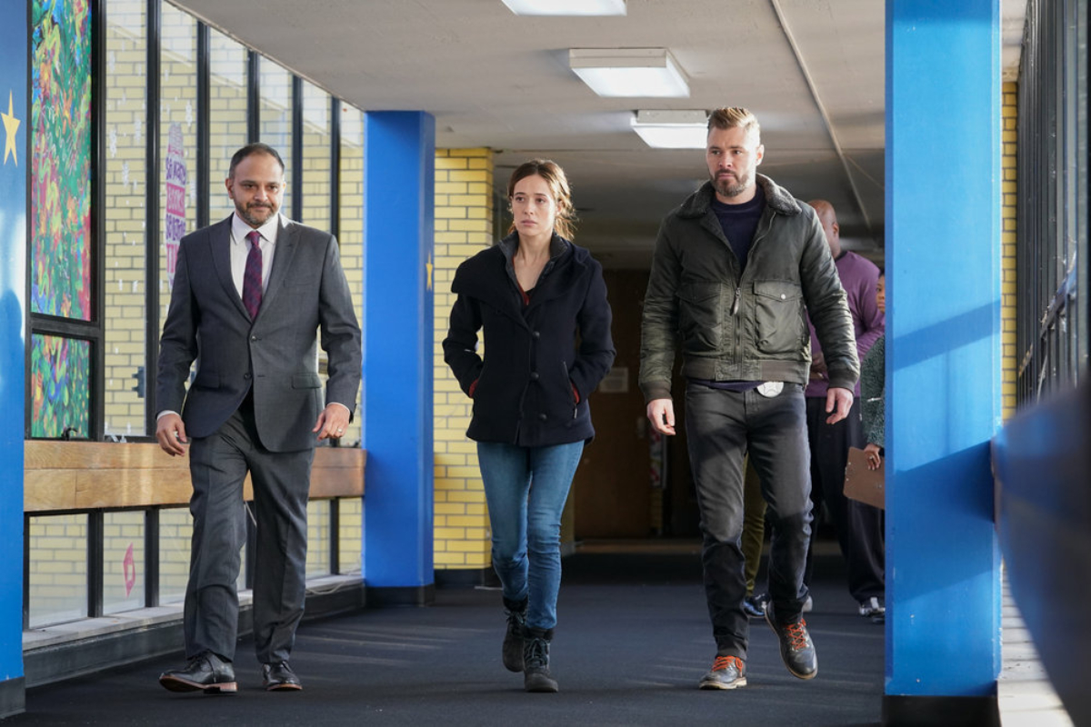 Marina Squerciati as Kim Burgess, Patrick John Flueger as Adam Ruzek in Chicago P.D. Season 9. Burgess and Ruzek walk through Mikayla's school with a teacher.