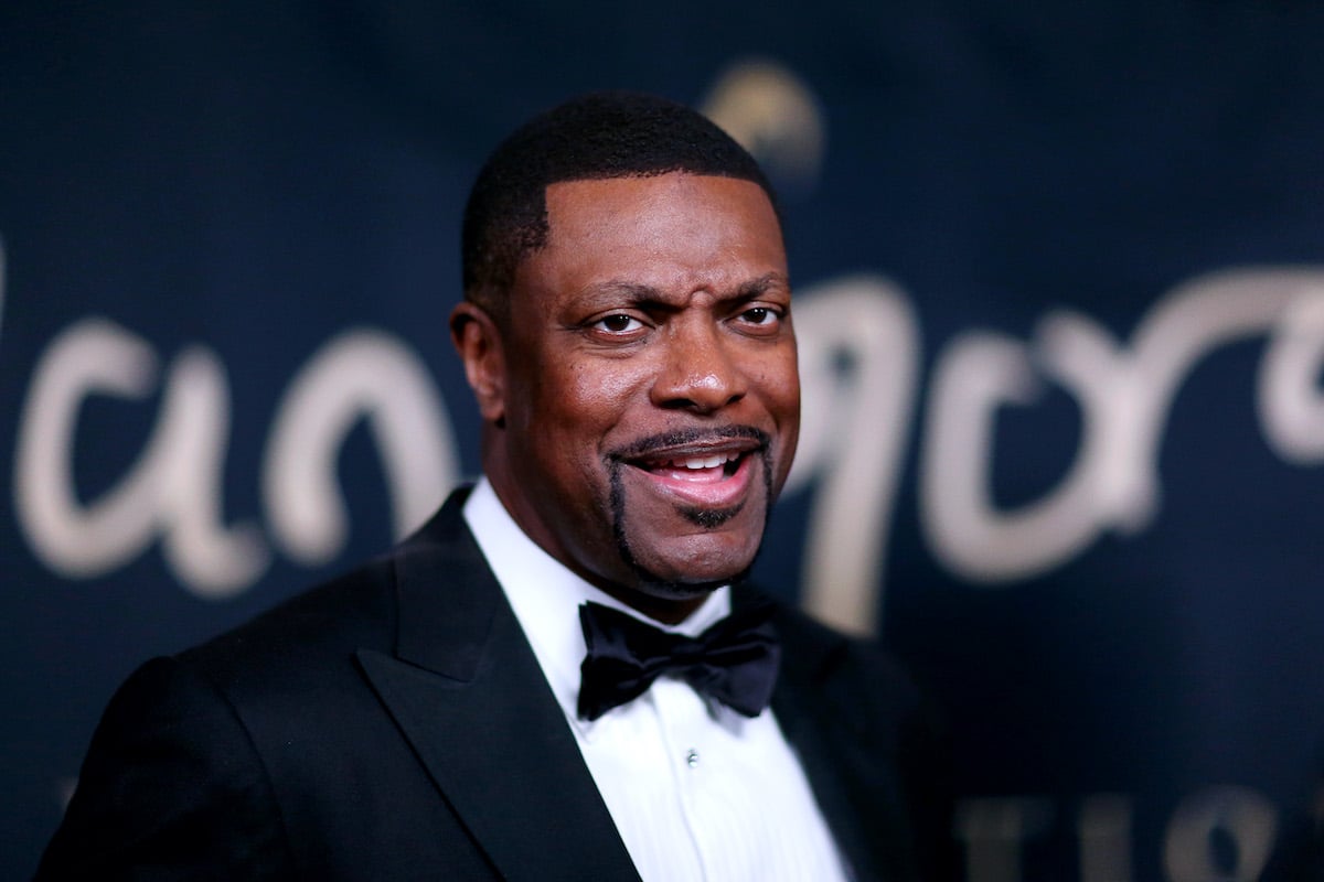 Chris Tucker wears a dark suit and furrows his brow of camera