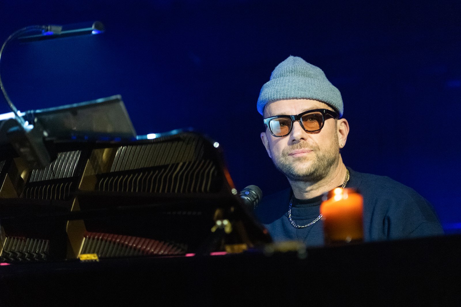 Damon Albarn wearing a beanie on stage