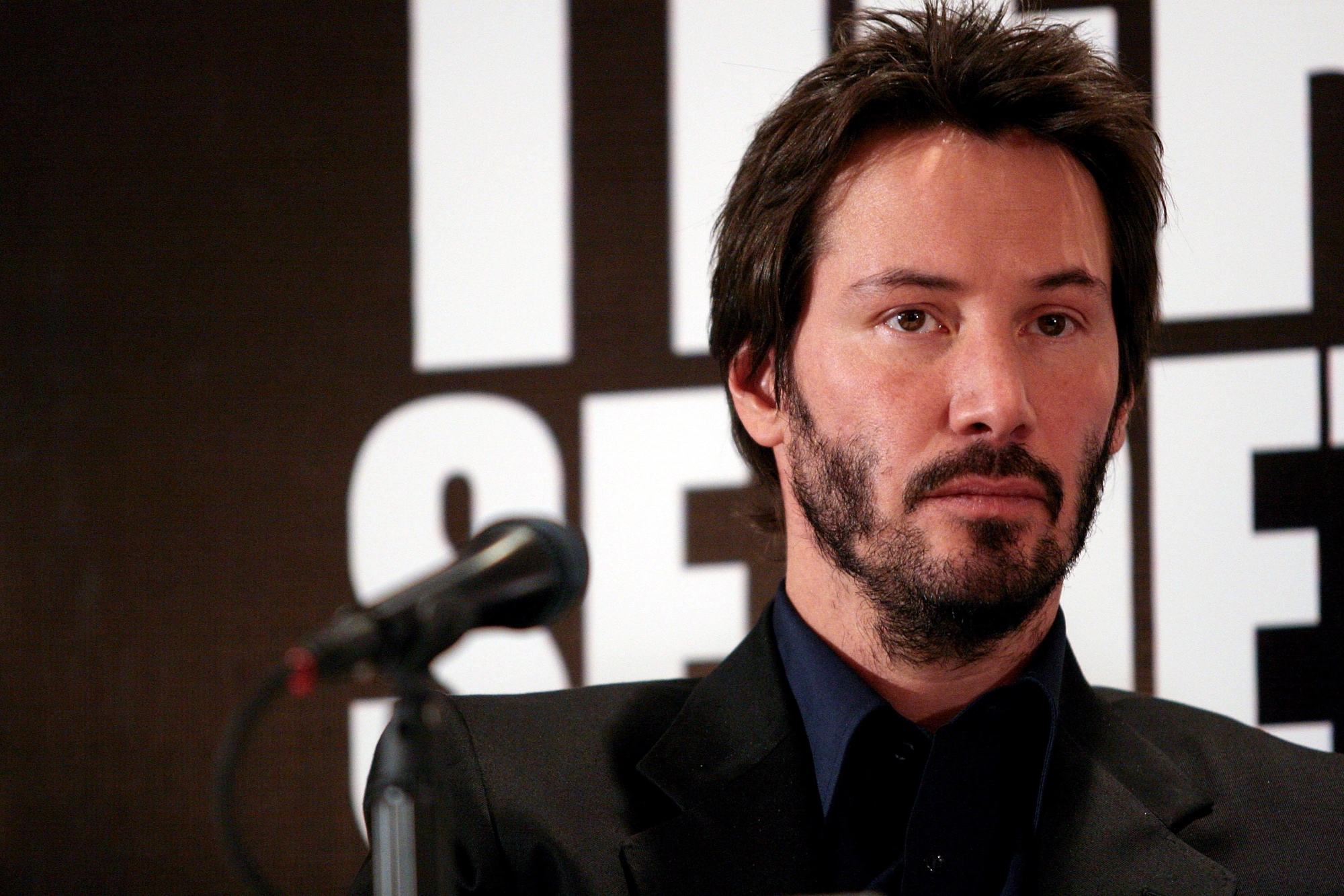 'Dangerous Liaisons' star Keanu Reeves sitting in front of a microphone