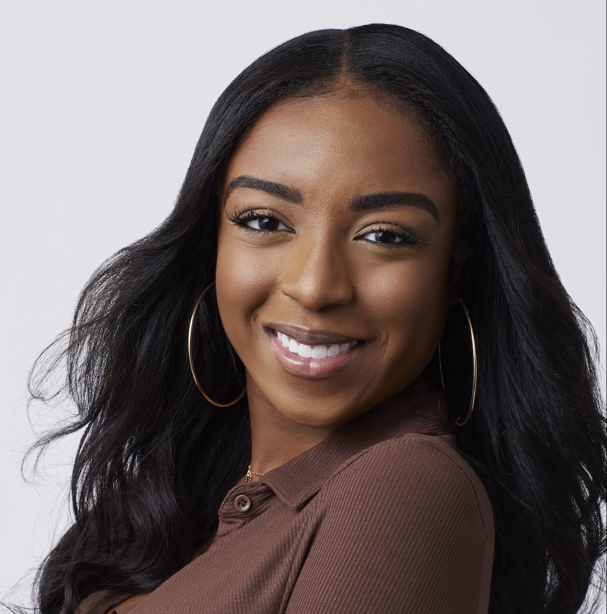 Daria Rose wearing a brown shirt with black hair during a promotional photoshoot for 'The Bachelor' Season 26