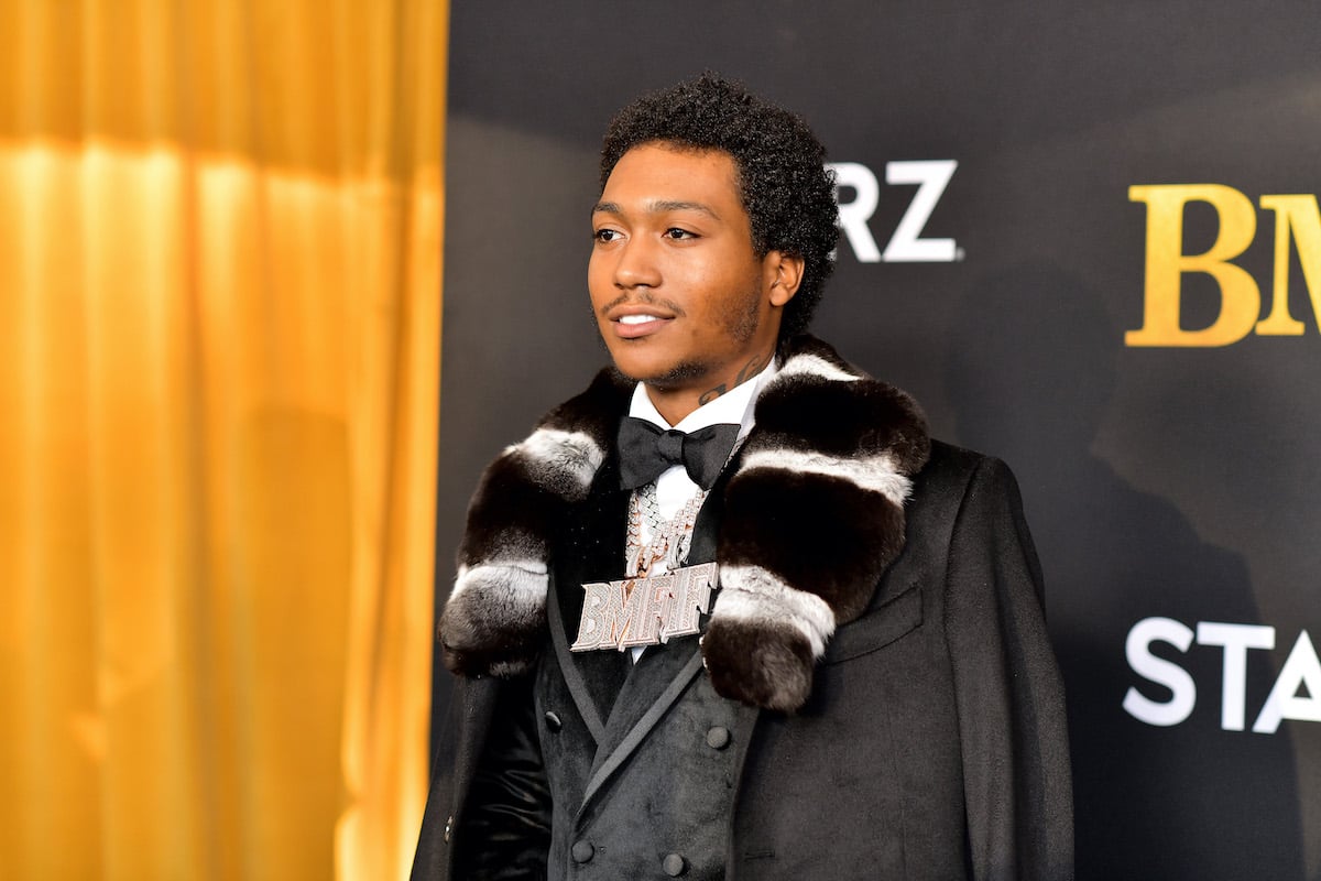 Demetrius “Lil Meech” Flenory Jr. smiling in front of a yellow and black backdrop