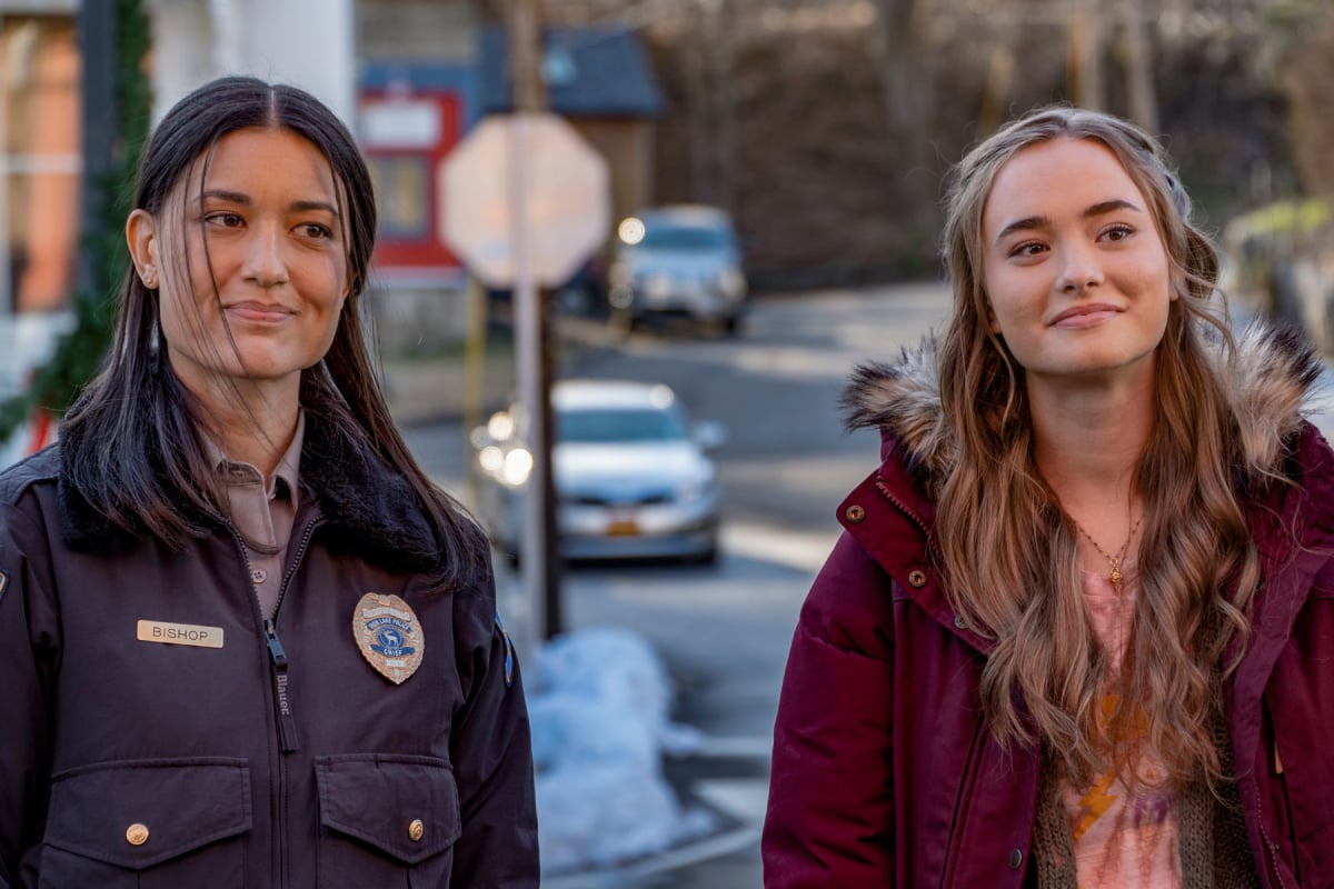 Julia Jones as Angela and Johnny Sequoyah as Audrey in Dexter: New Blood. Angela and Audrey stand next to each other and smile.