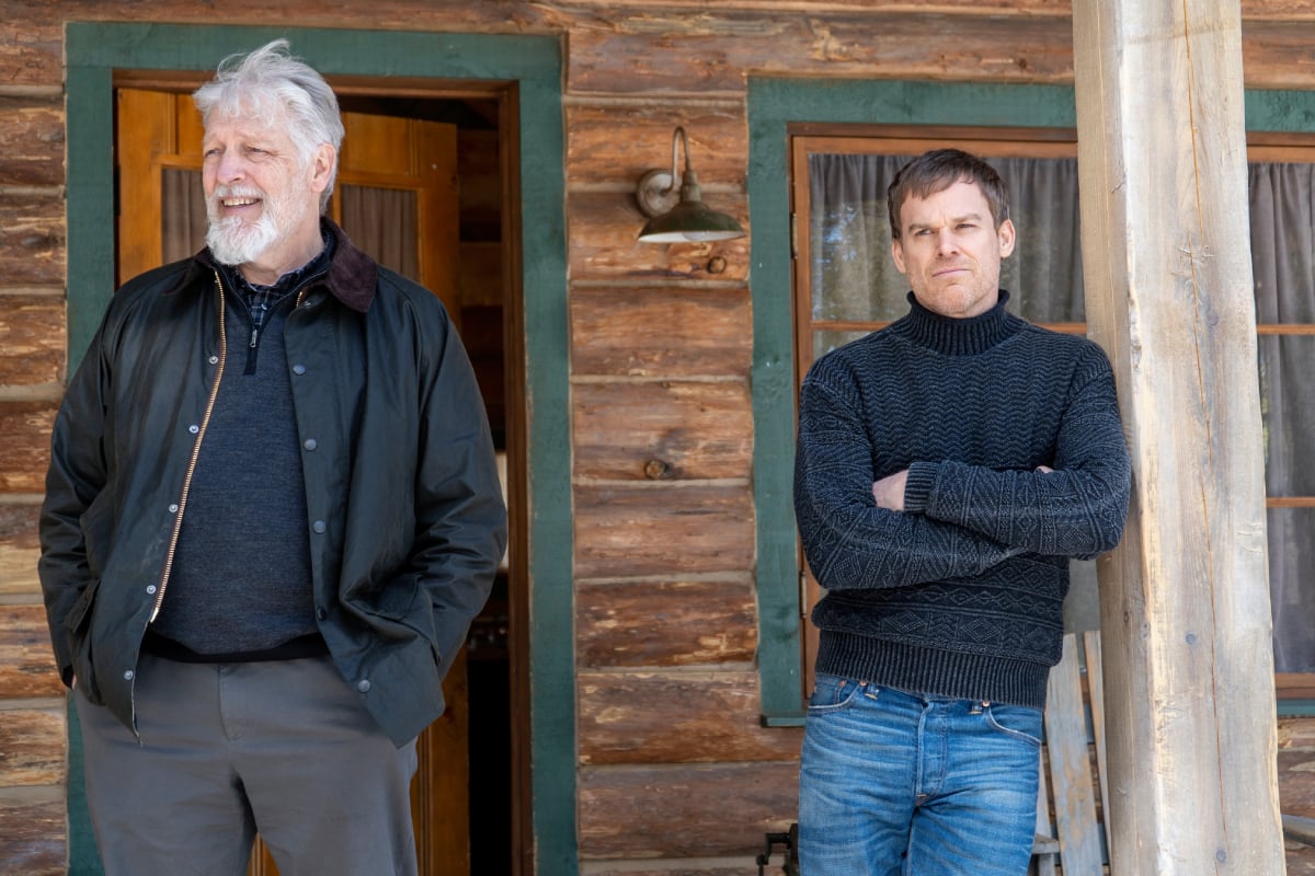 Clancy Brown as Kurt and Michael C. Hall as Dexter in Dexter: New Blood. Kurt and Dexter stand on the front porch of a cabin. 