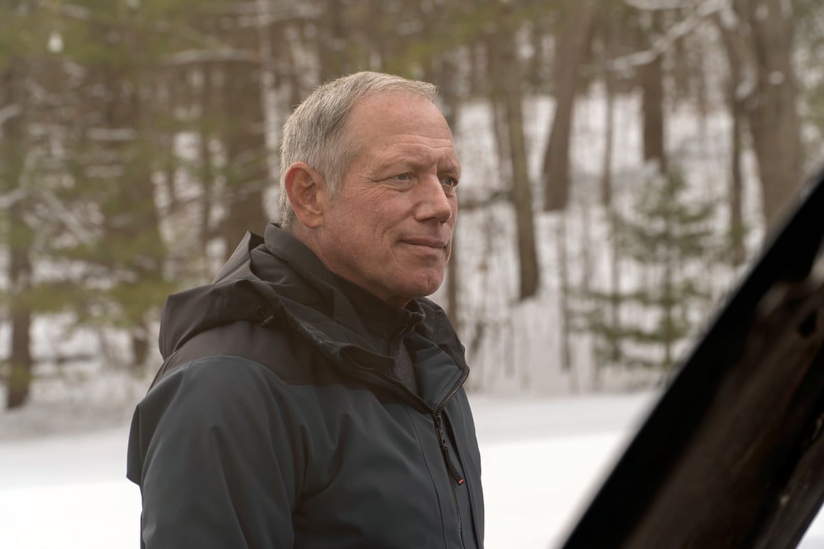 Fredric Lehne as Edward Olsen in Dexter: New Blood. Olsen wears a dark coat and stands beside a car.