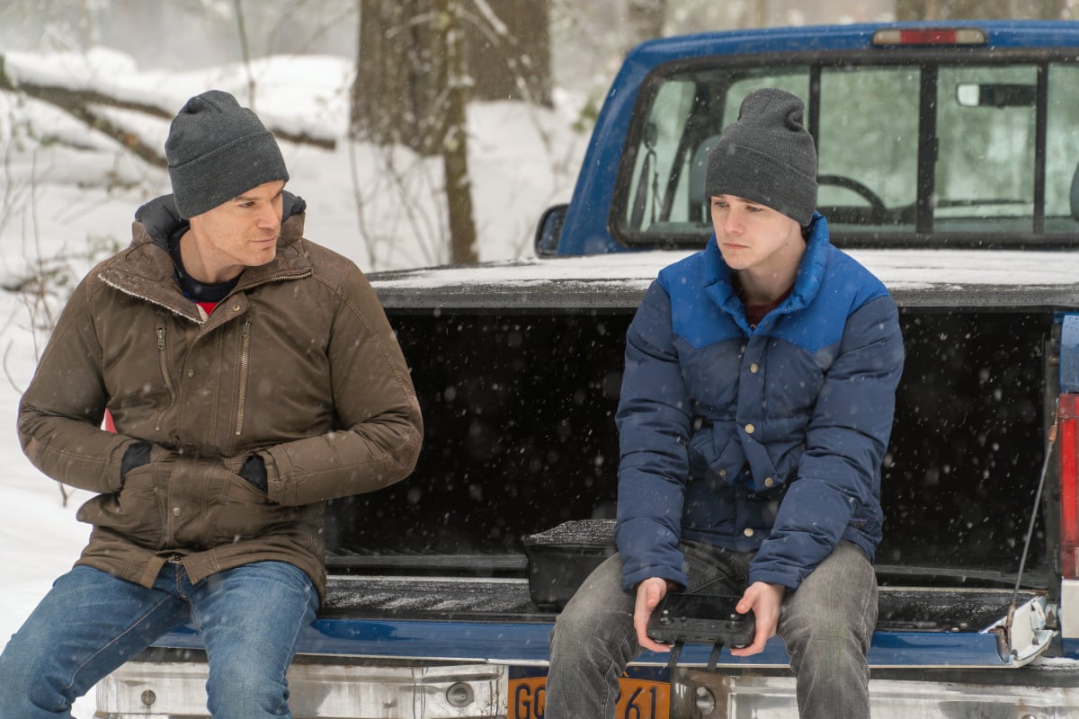 Michael C. Hall as Dexter and Jack Alcott as Harrison in Dexter: New Blood. Dexter and Harrison sit in the bed of Dexter's truck. Harrison is holding the remote control to his drone.