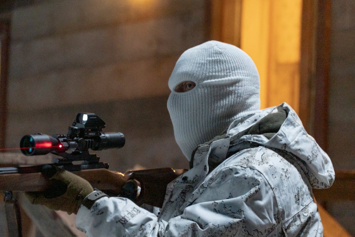 Clancy Brown as Kurt in Dexter: New Blood. Kurt wears his snowsuit and white ski mask and points a rifle at someone.