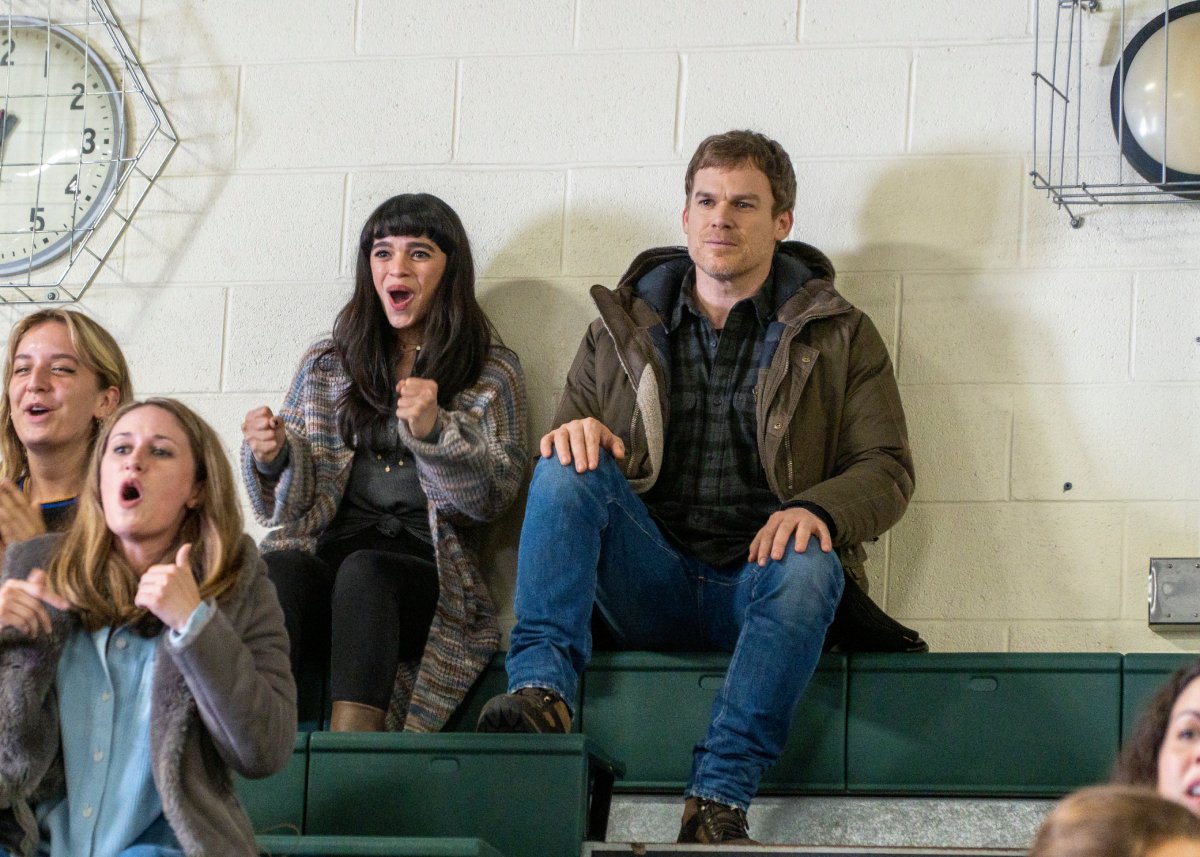 Gizel Jimenez as Tess and Michael C. Hall as Dexter in Dexter: New Blood. Tess sits on the bleachers of the gym next to Dexter and cheers.