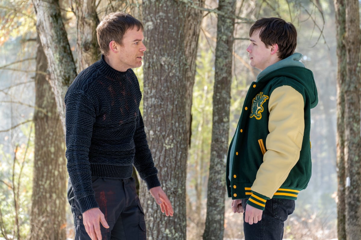 Michael C. Hall as Dexter and Jack Alcott as Harrison in Dexter: New Blood. Dexter and Harrison face each other in the snowy woods.