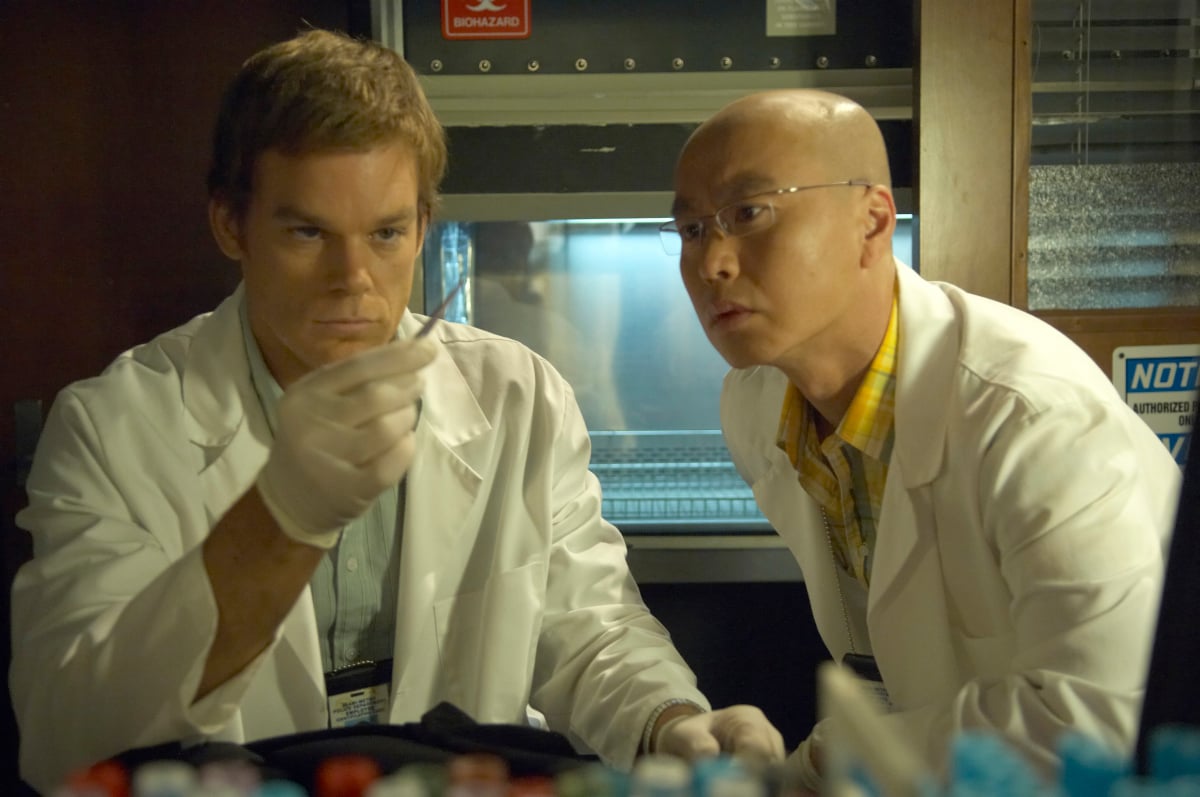 Dexter Morgan and Vince Masuka observe an object at work at the Miami Metro Police Department