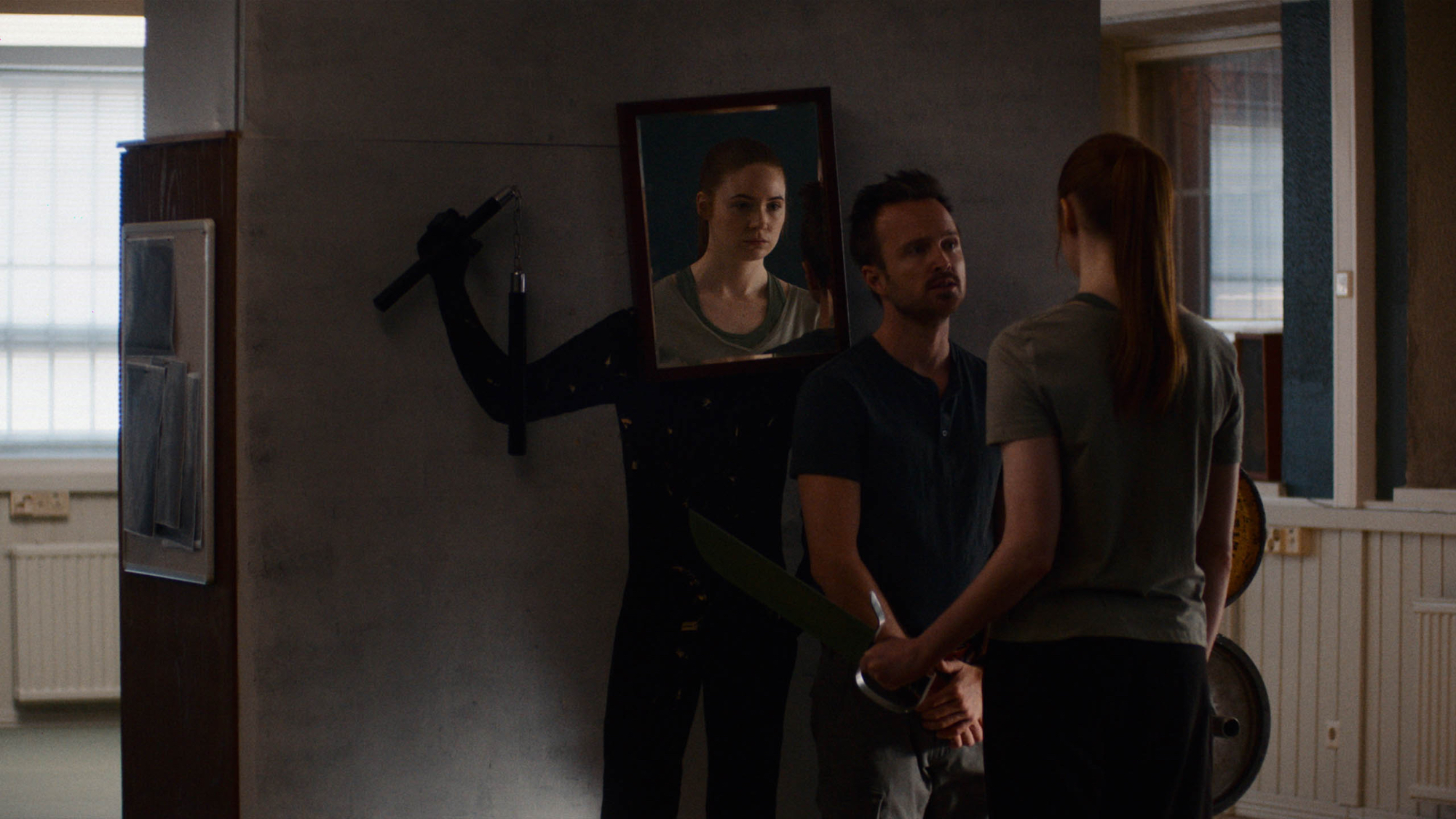 'Dual' Aaron Paul as Trent and Karen Gillan as Sarah standing in front of mirror practicing
