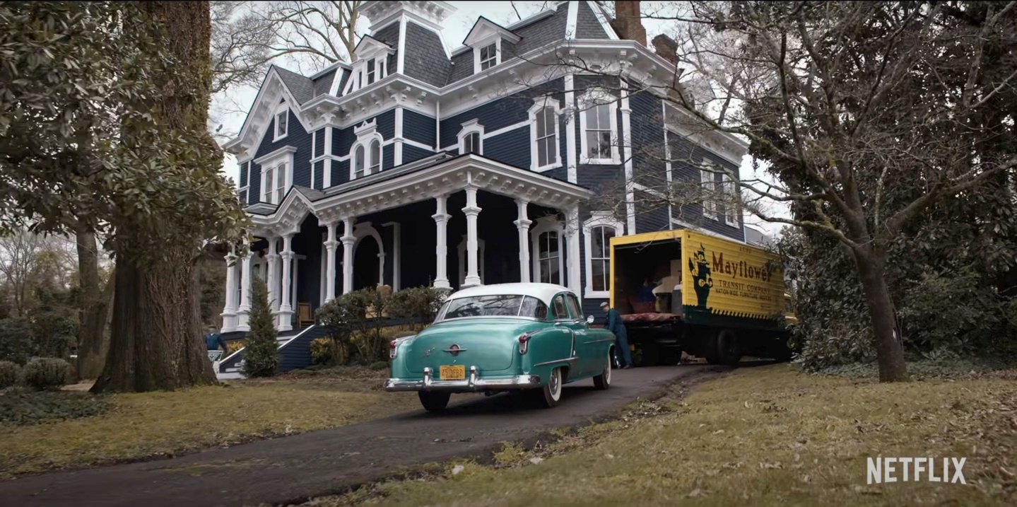 A mint green car pulls up to a large Victorian house in a scene from Stranger Things Season 4.