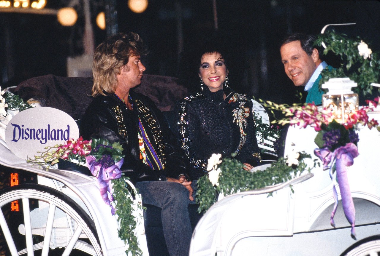 Larry Fortensky, Elizabeth Taylor, and Michael Eisner seated in a Disneyland carriage